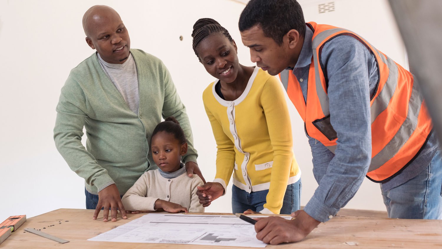 A family and a contractor talking about home plans