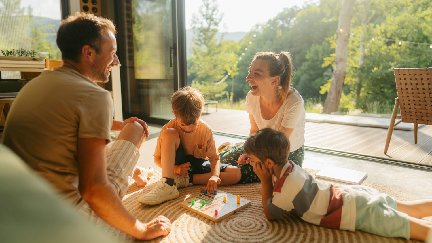 Young family playing board games together on the floor of their home