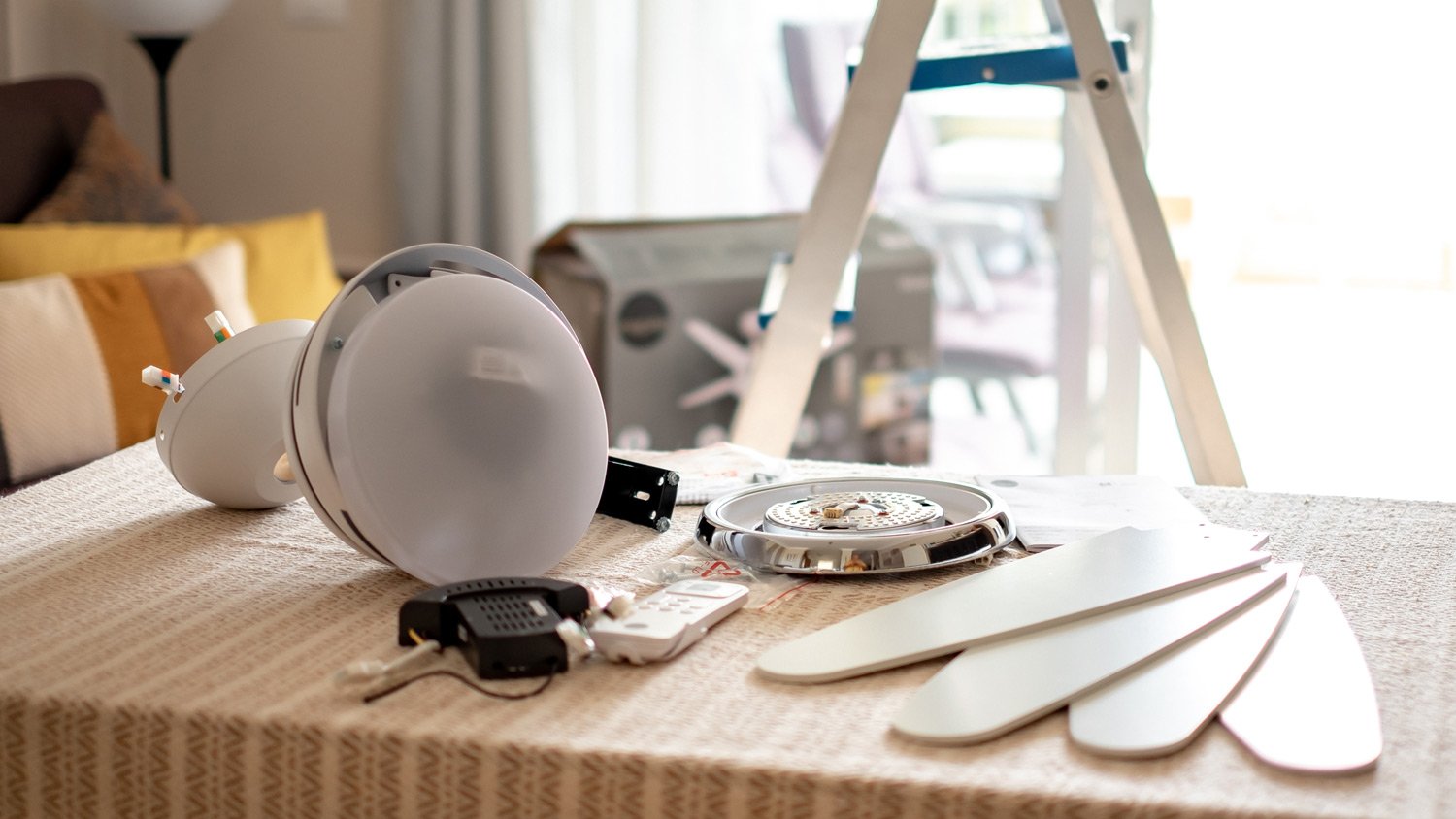 Accessories on the table ready to be assembled to install a paddle fan on the ceiling of the living room