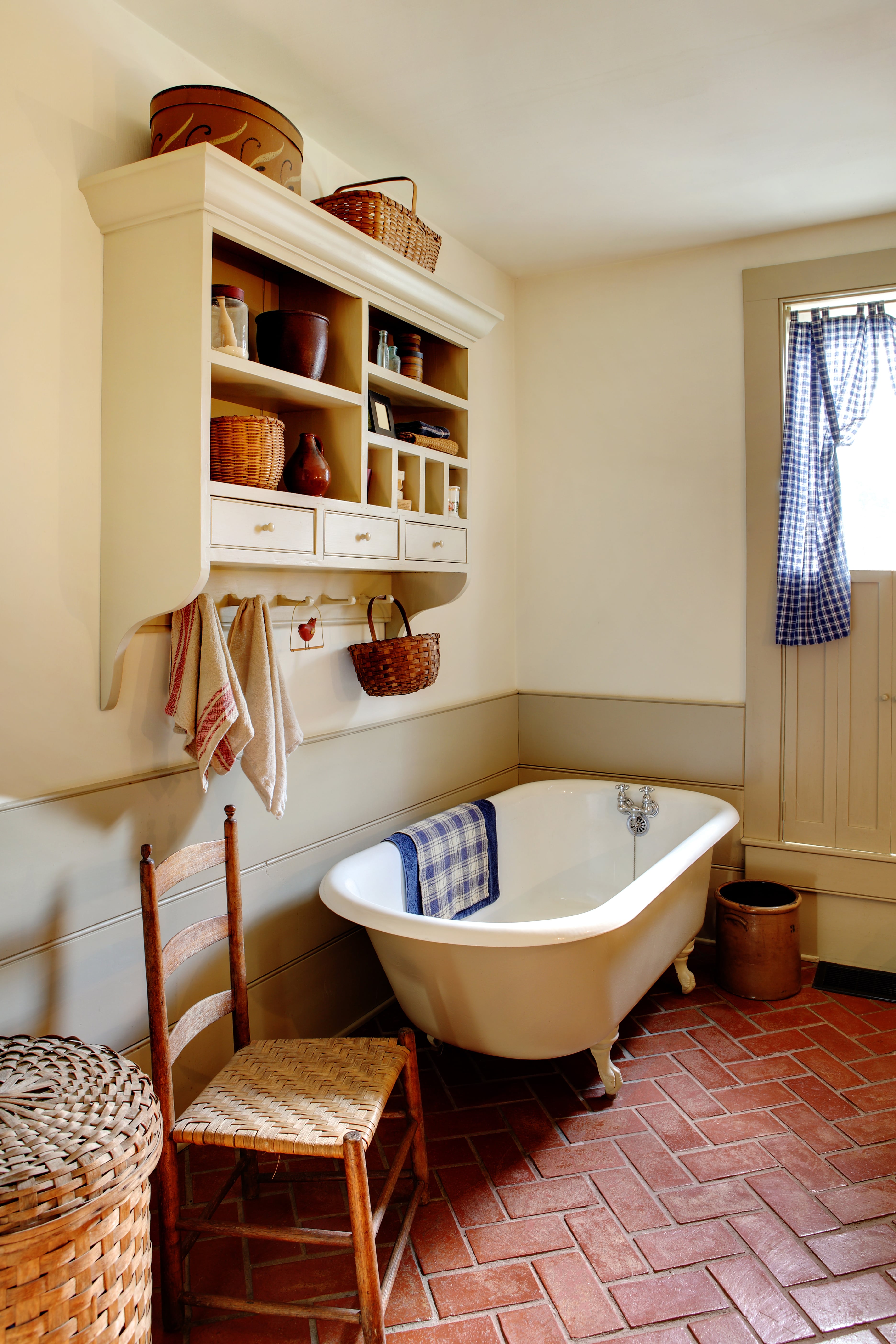 A small farmhouse style bathroom with brick flooring 