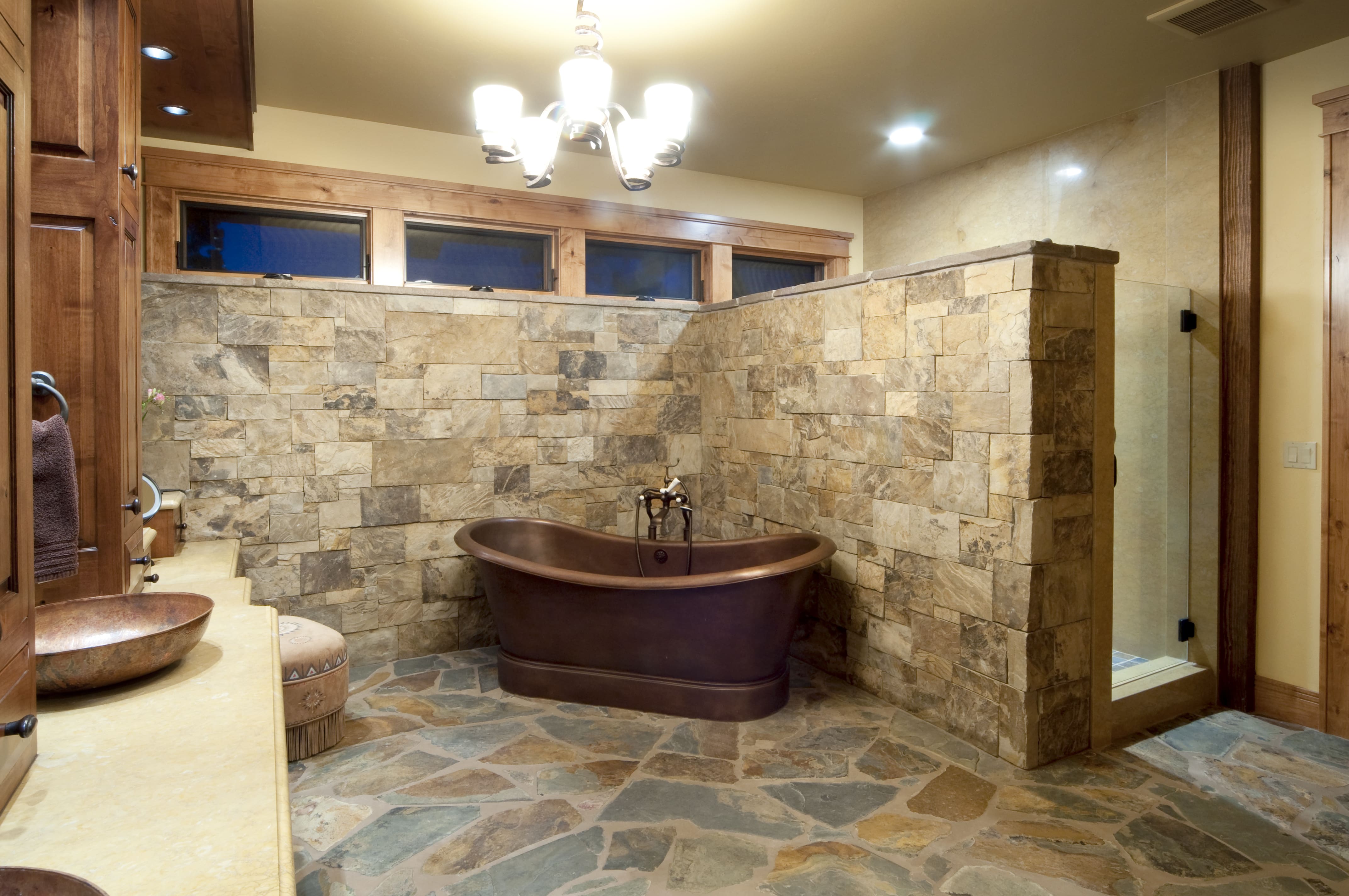 A large bathroom with a stone covered floor and walls