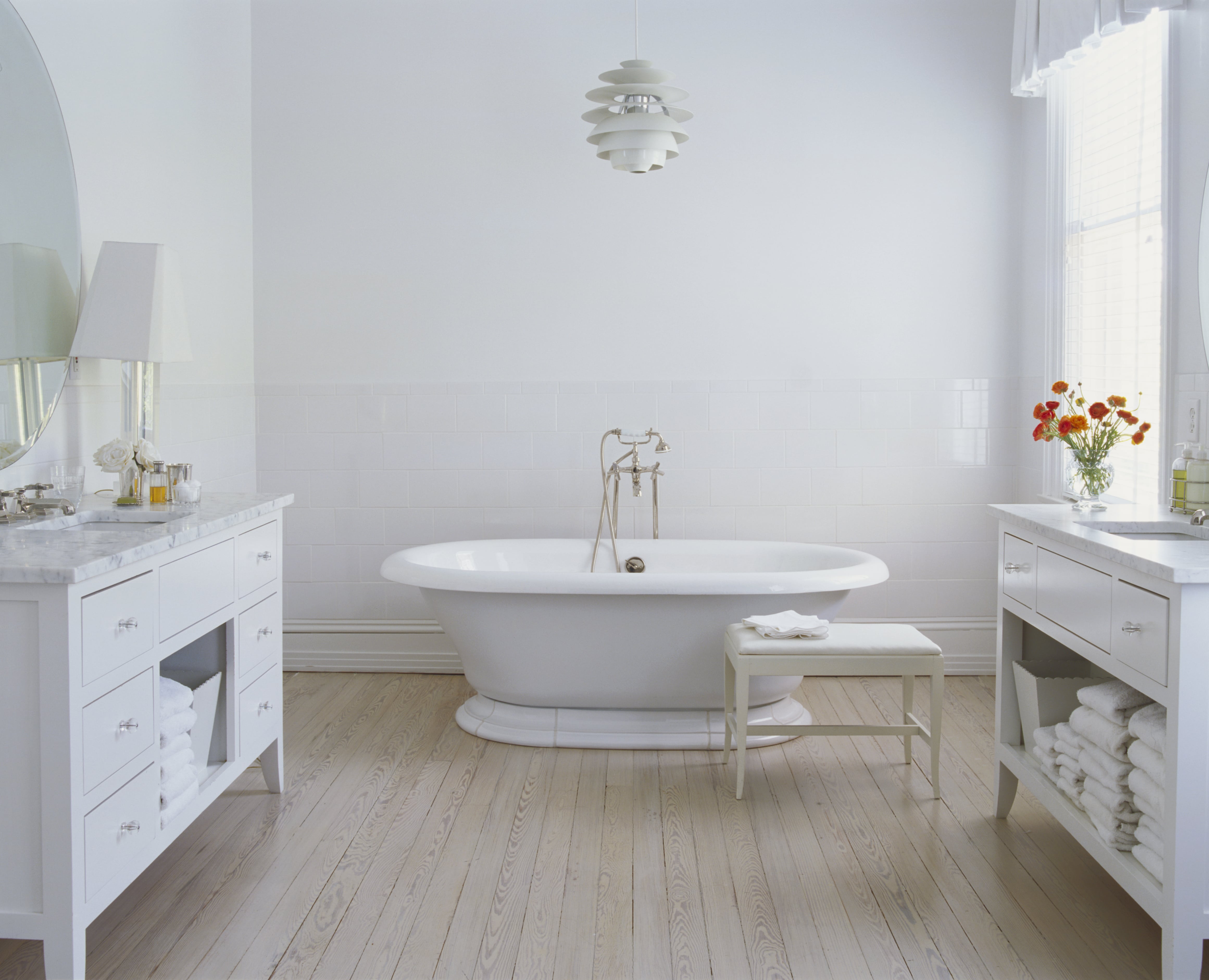A white colored bathroom with a pendant light hanging from the ceiling