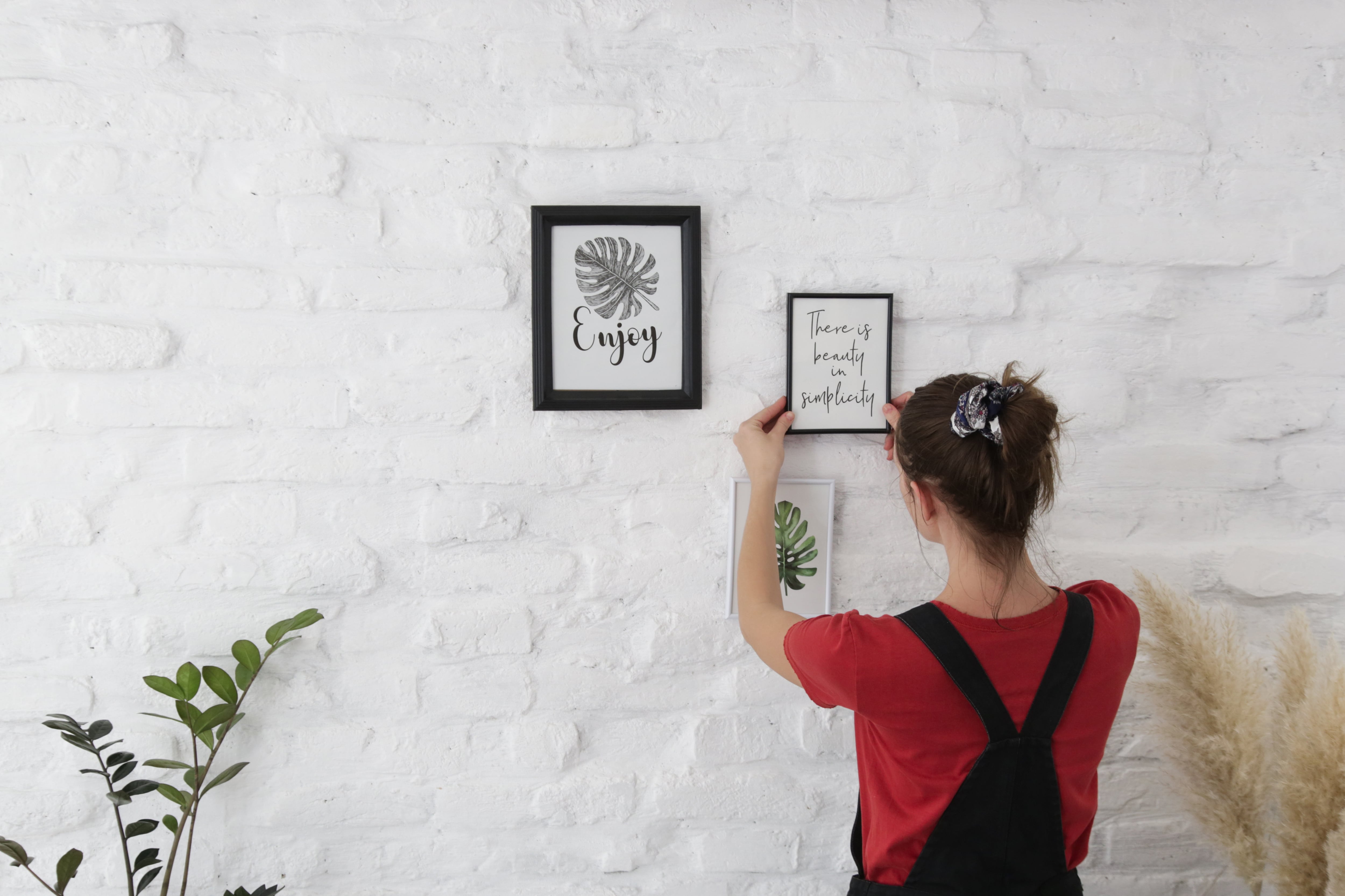 Woman hanging picture frames on wall