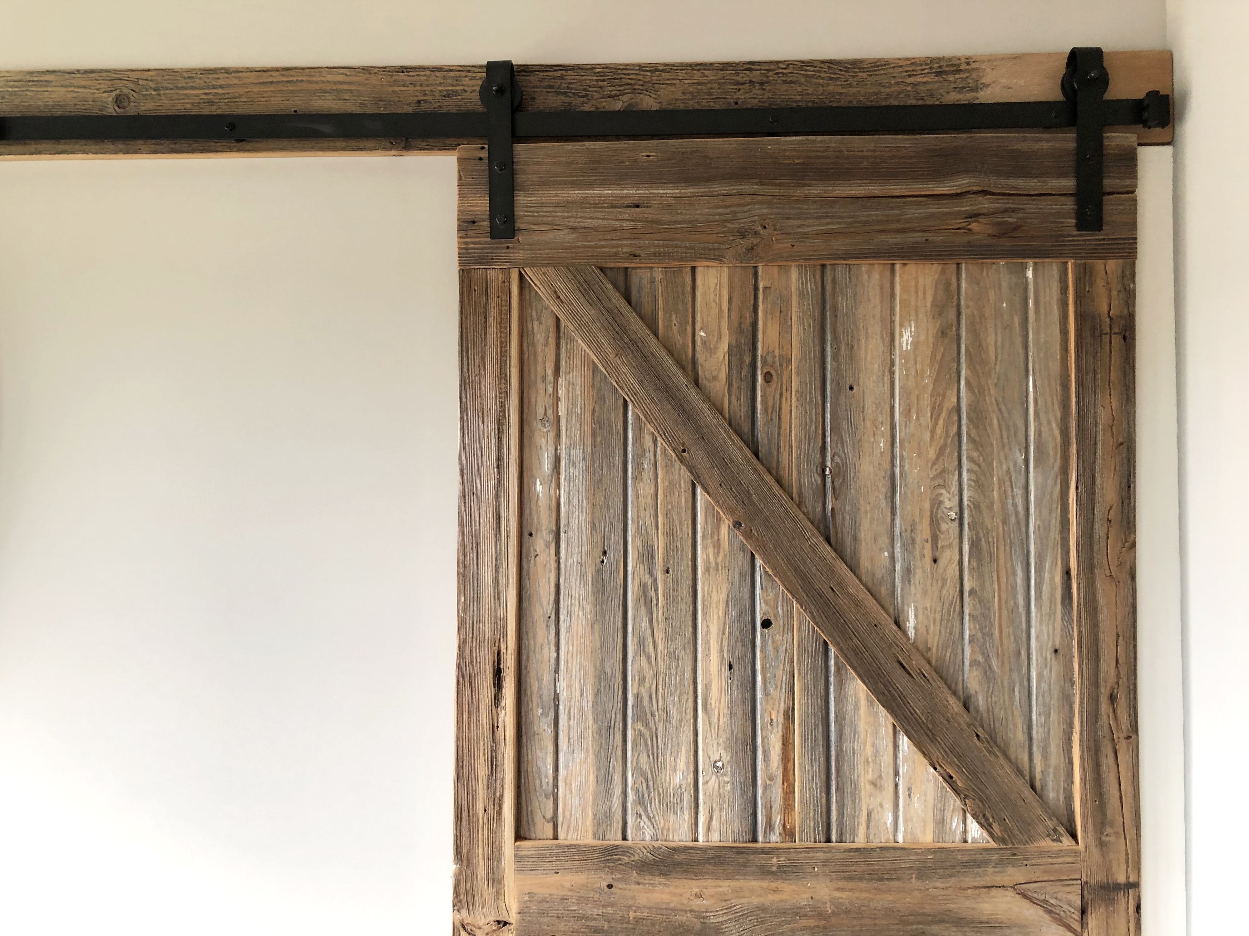 Distressed sliding barn door with black hardware