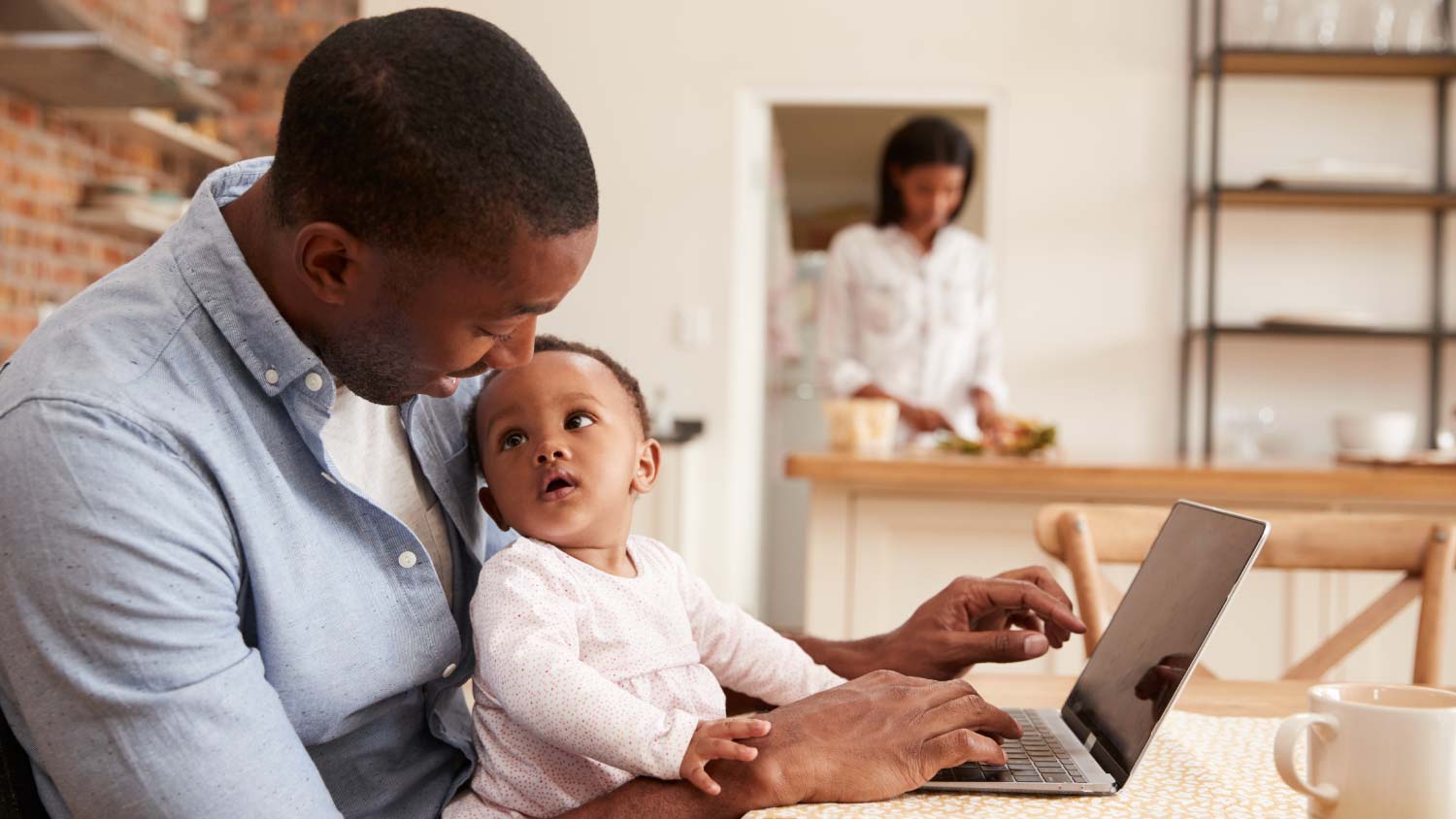 father and child working at laptop	