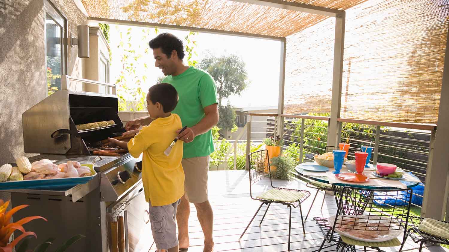 Father and son cooking diner on the grill 