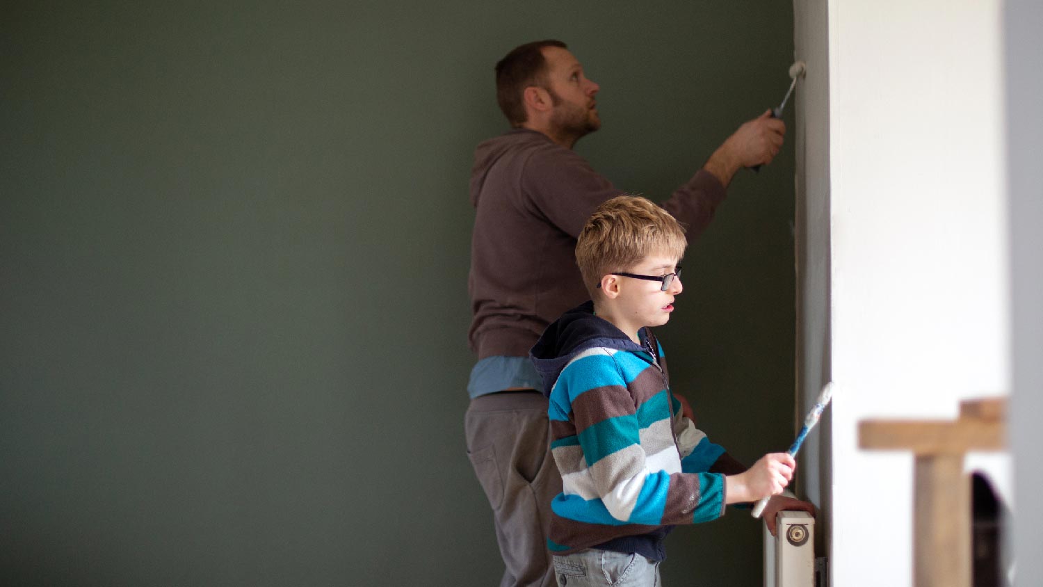 A father and his son painting a bedroom