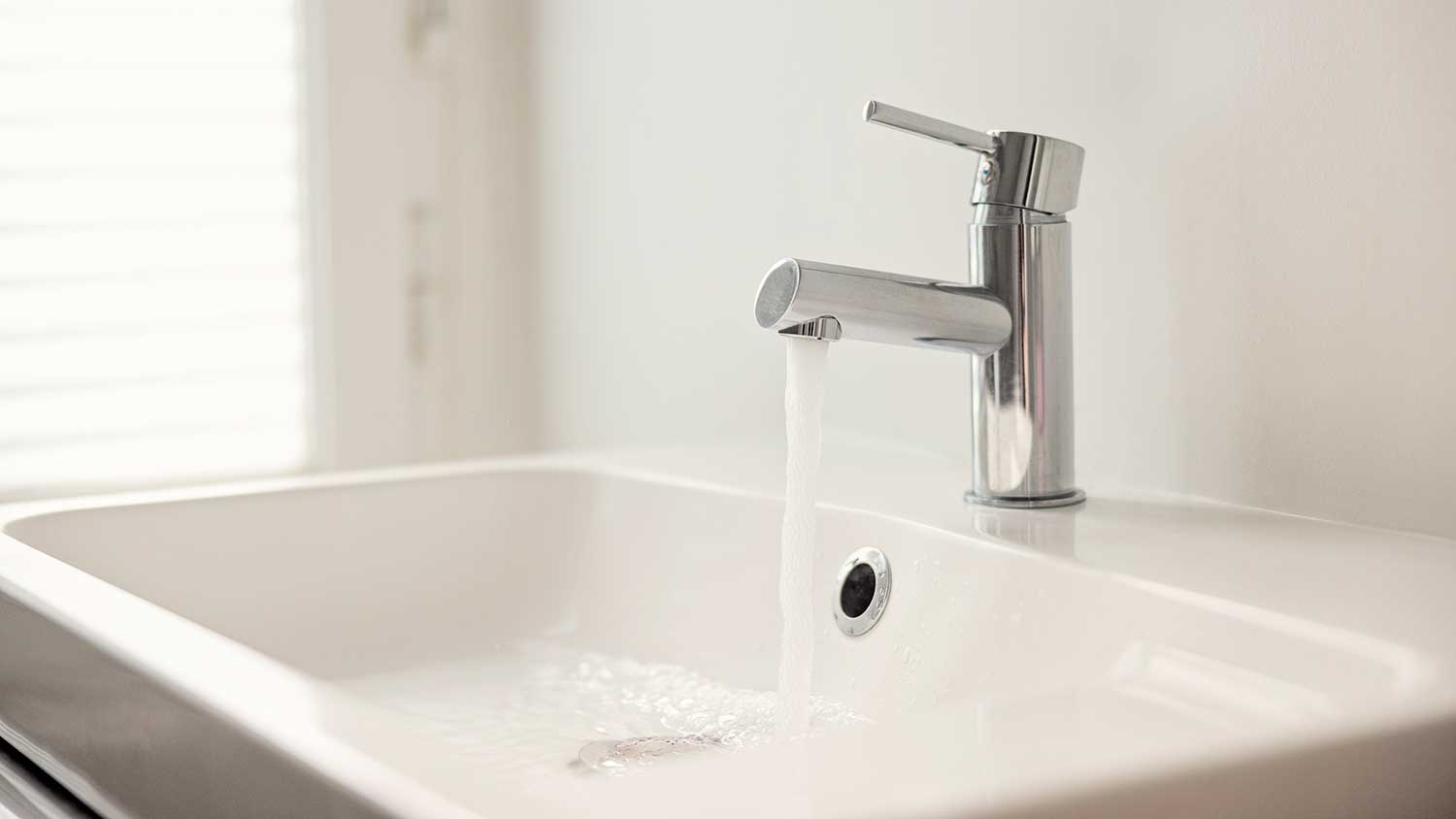 Chrome bathroom faucet with running water