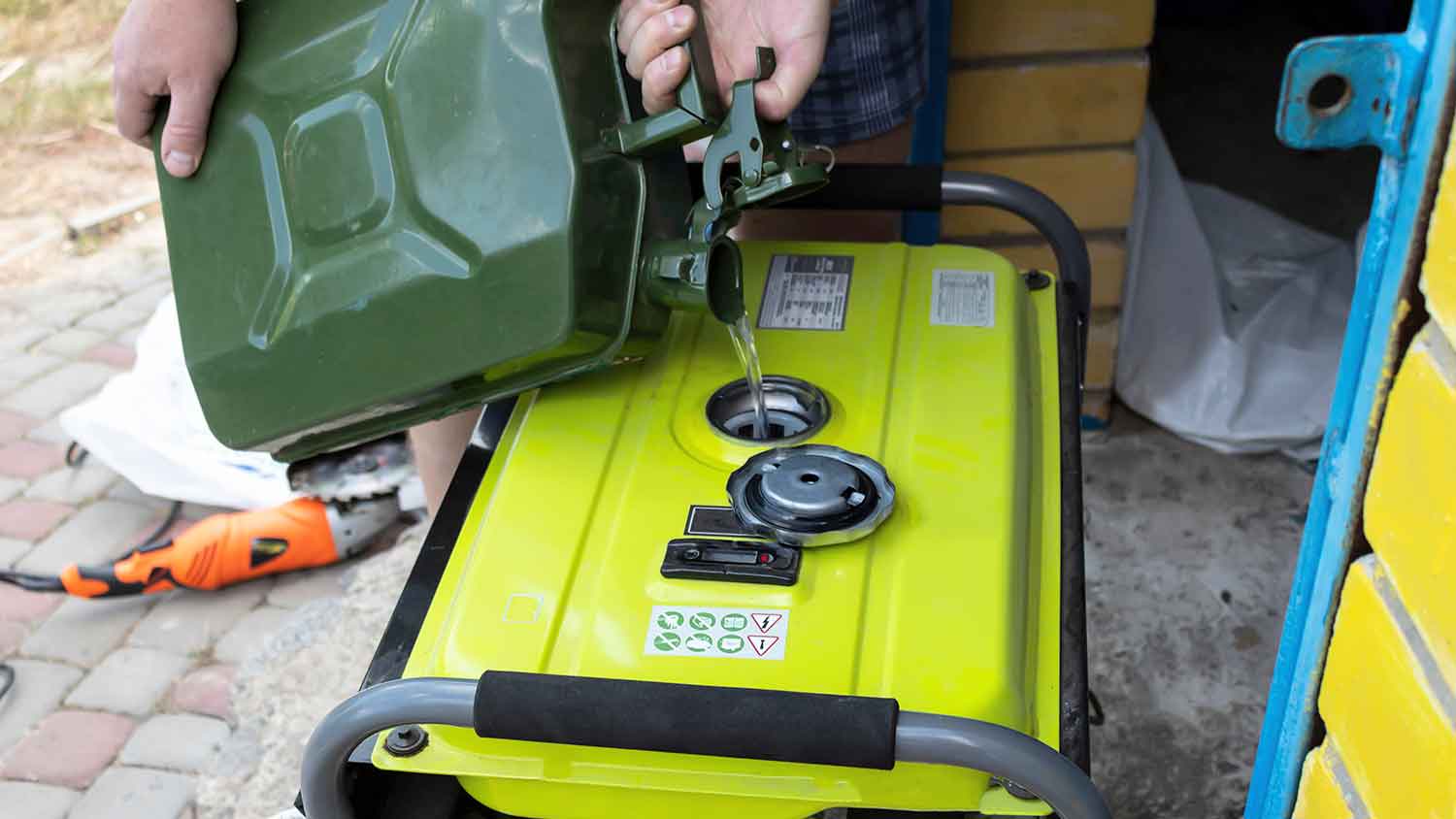 Man pouring gasoline into a portable generator