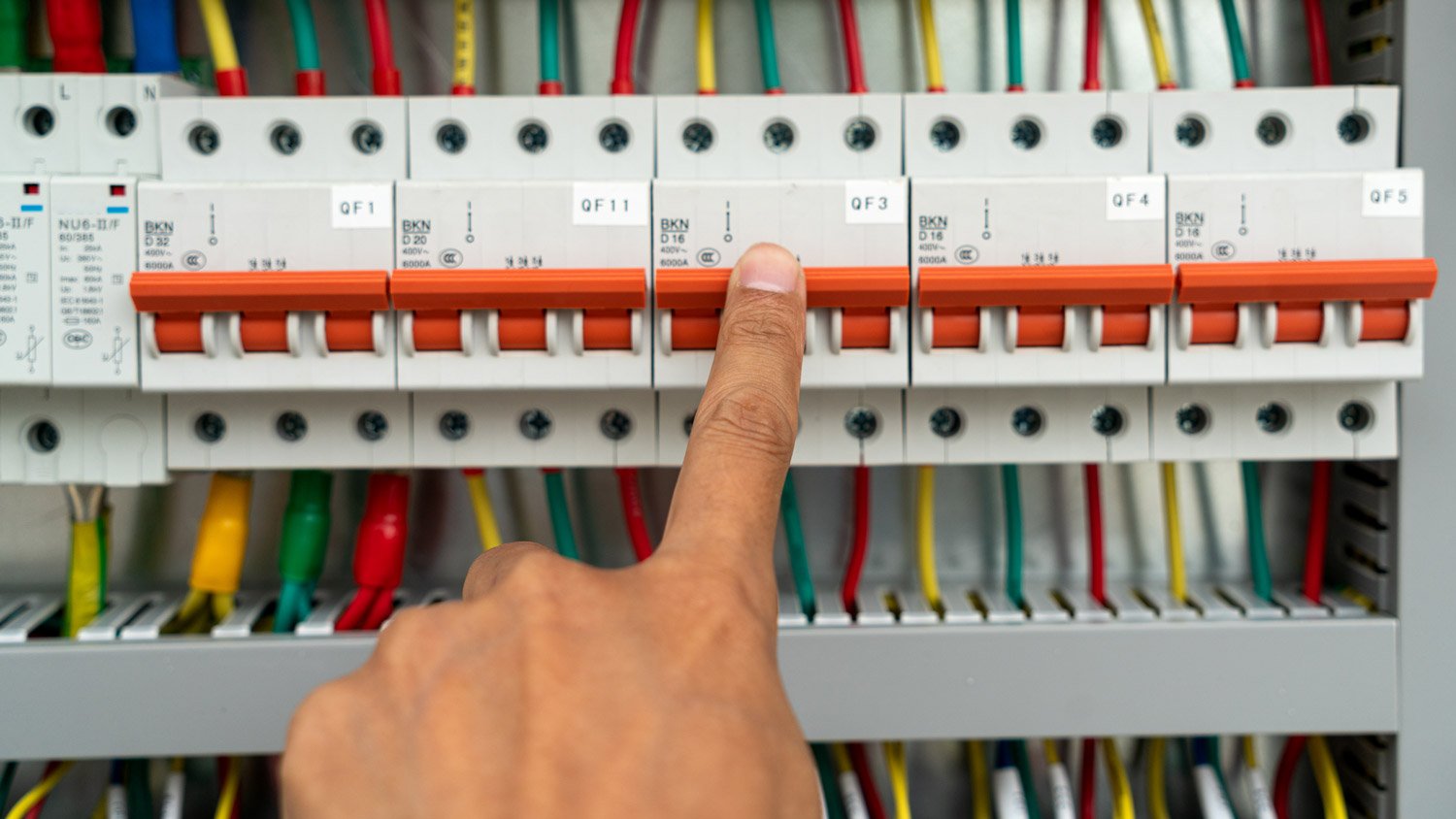 Close-up of a finger flipping the circuit breaker