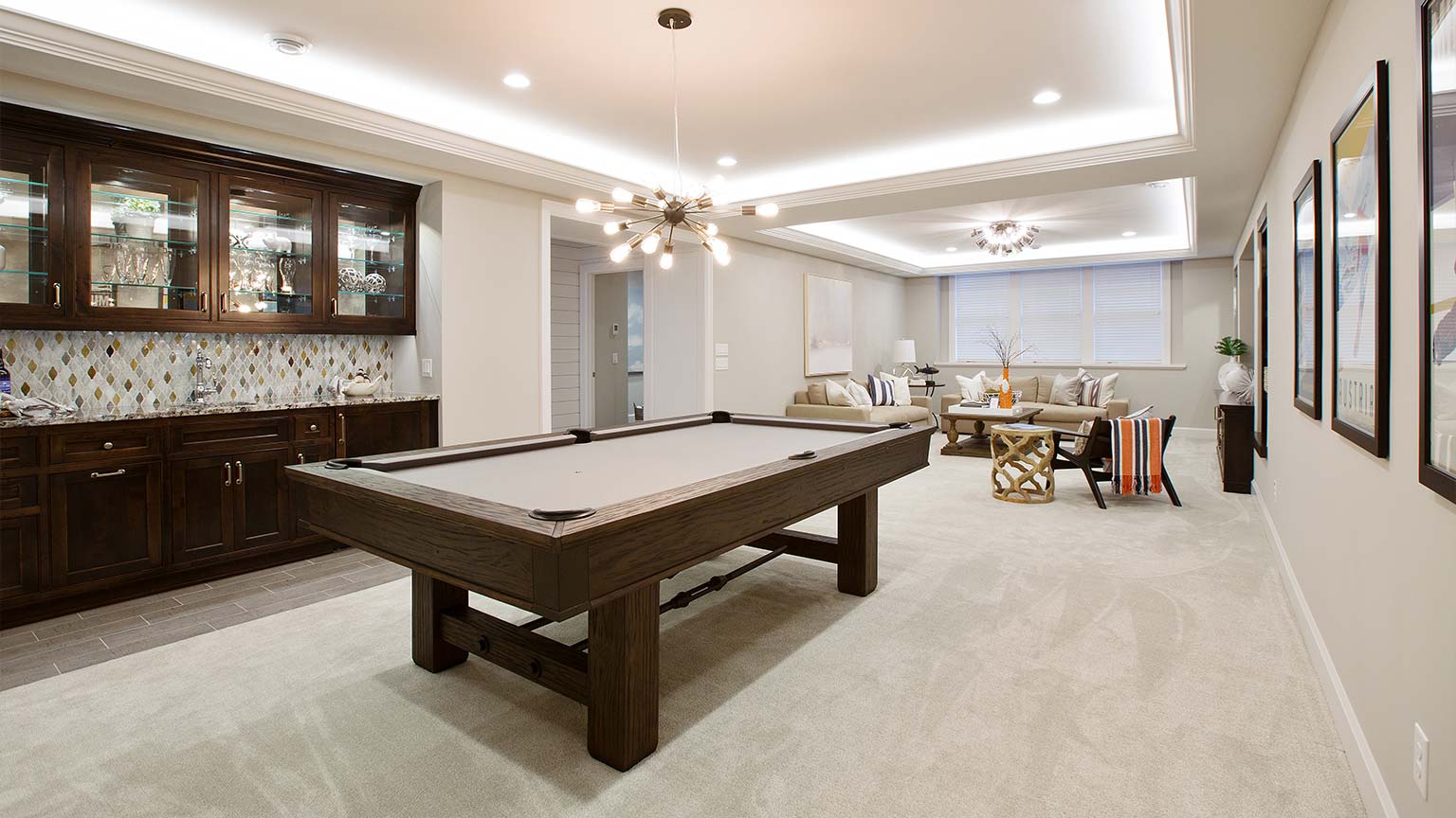 Beautiful basement entertaining room with billiards table and kitchenette