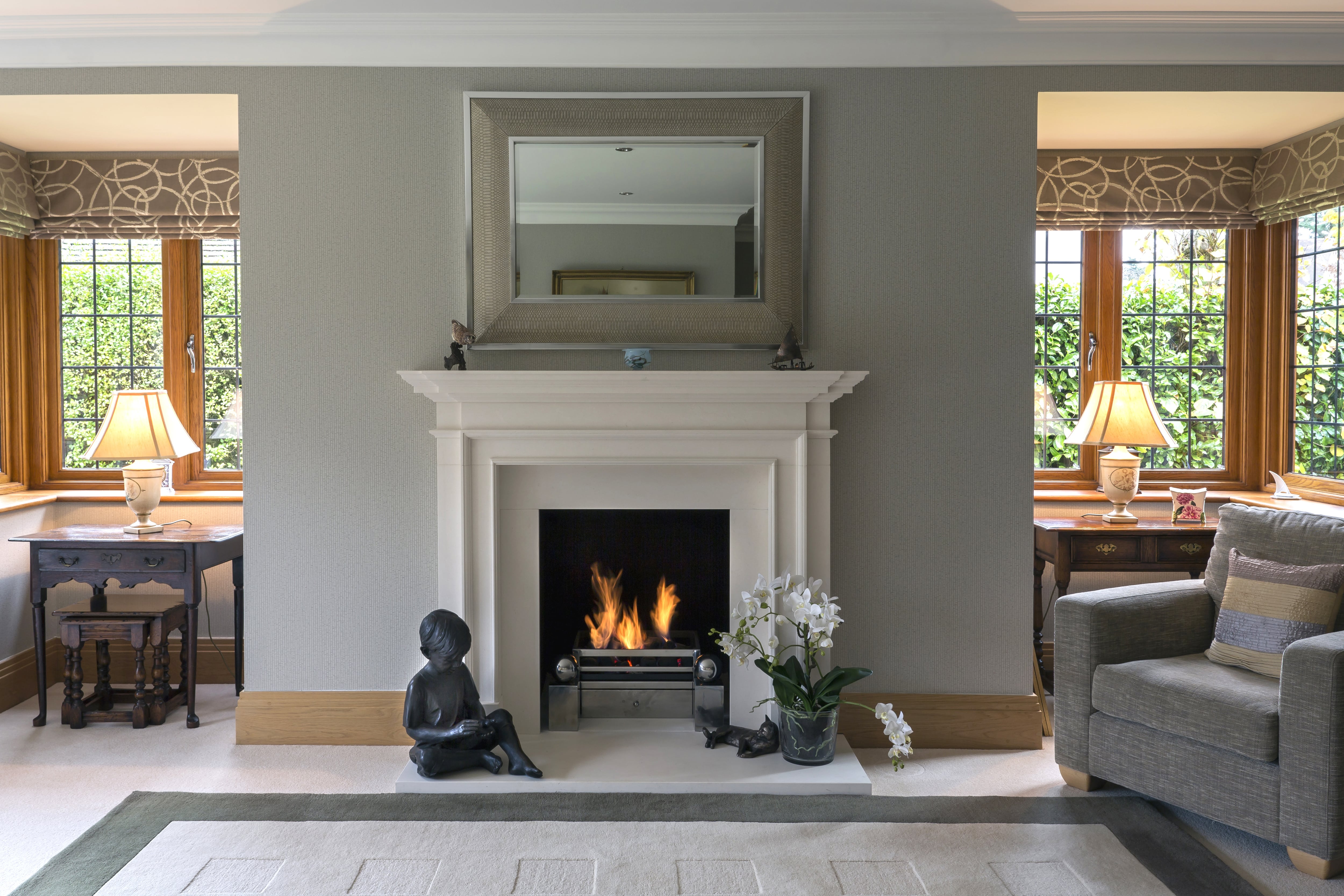 Modern white fireplace with hearth sculptures and a gray accent wall