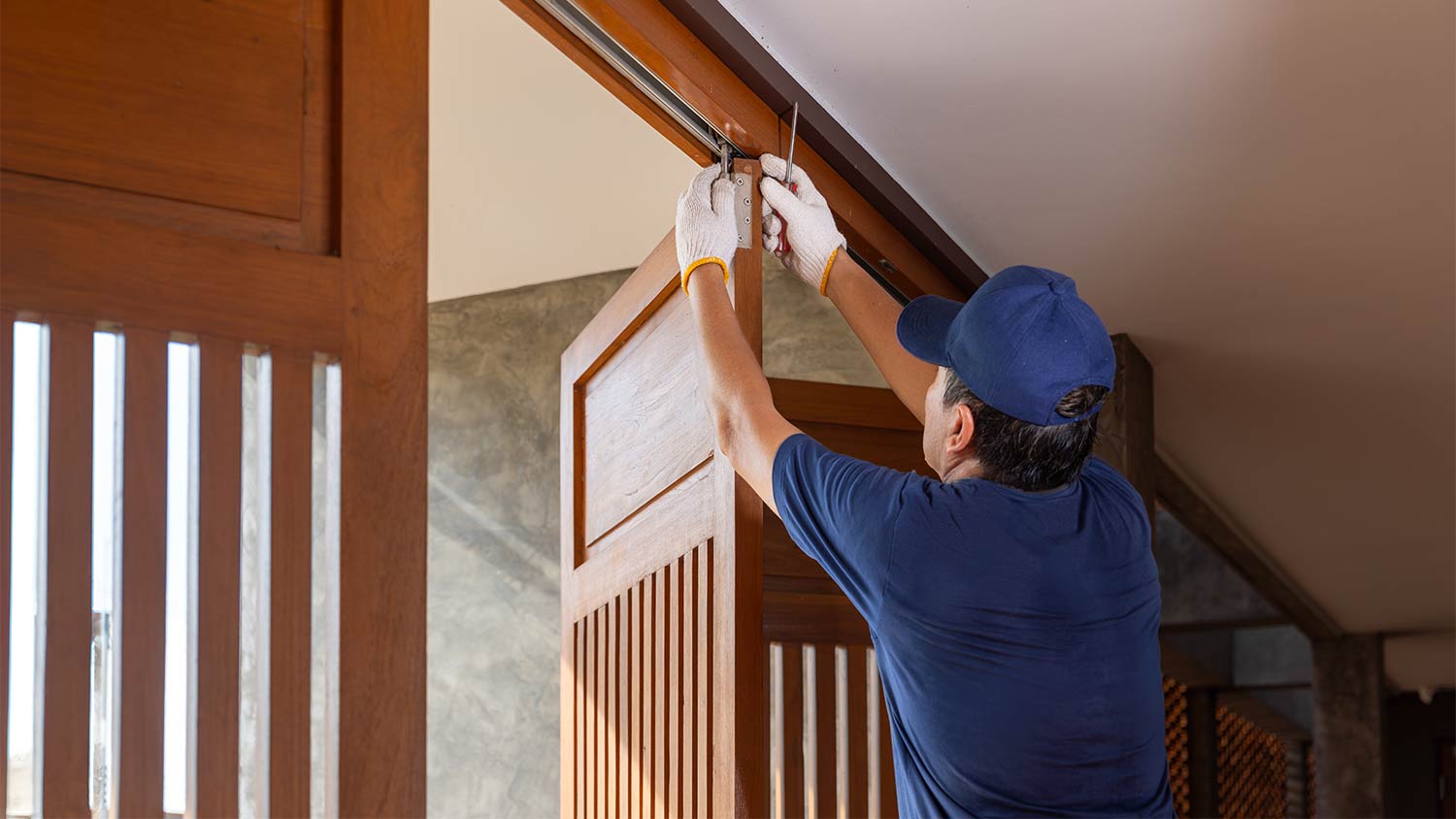 handy man fixing bifold doors 