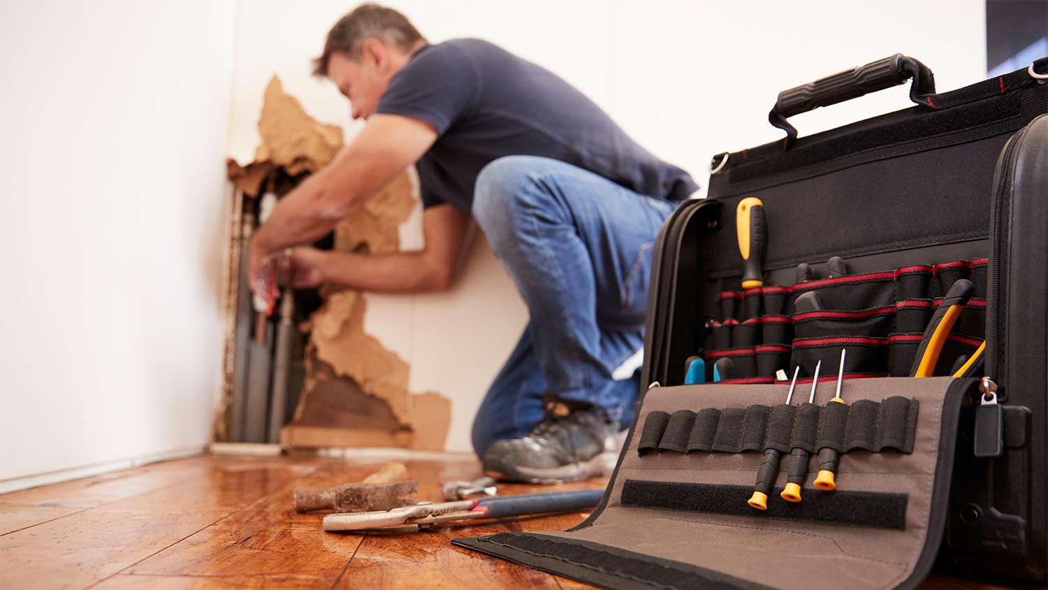 technician fixing burst pipe