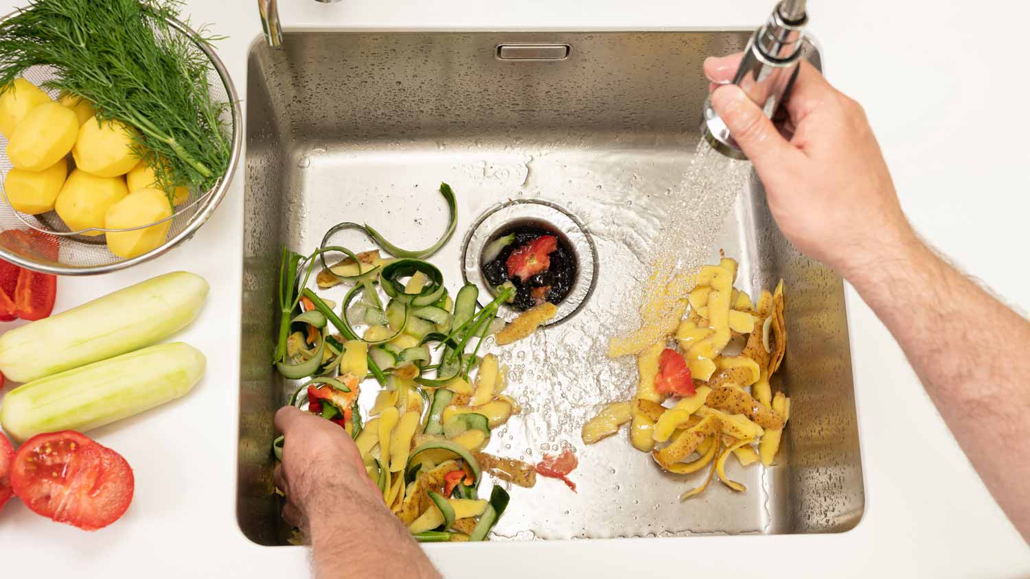 Man picking food waste from a kitchen sink