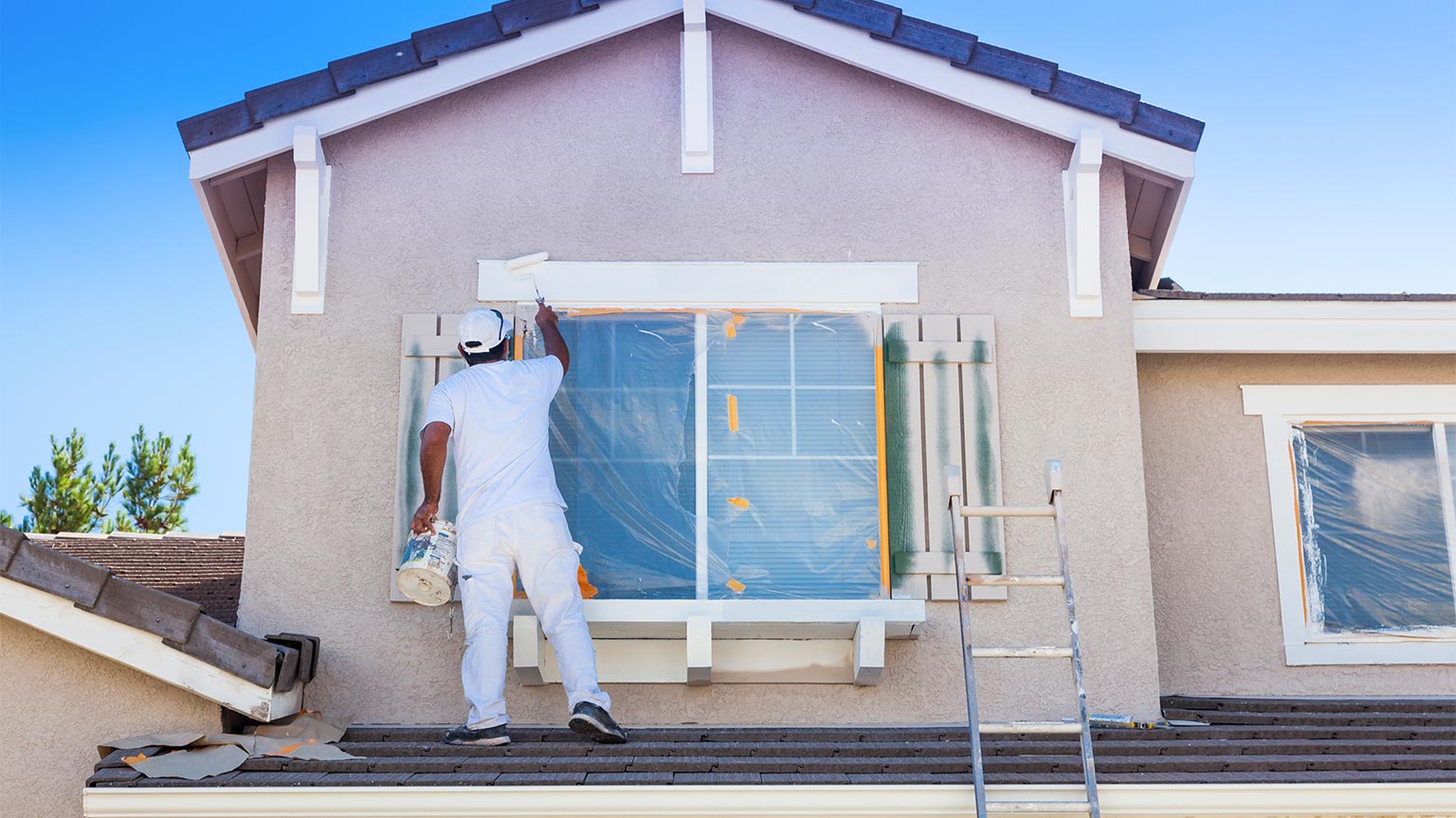 House Painter Painting the Trim And Shutters of Home