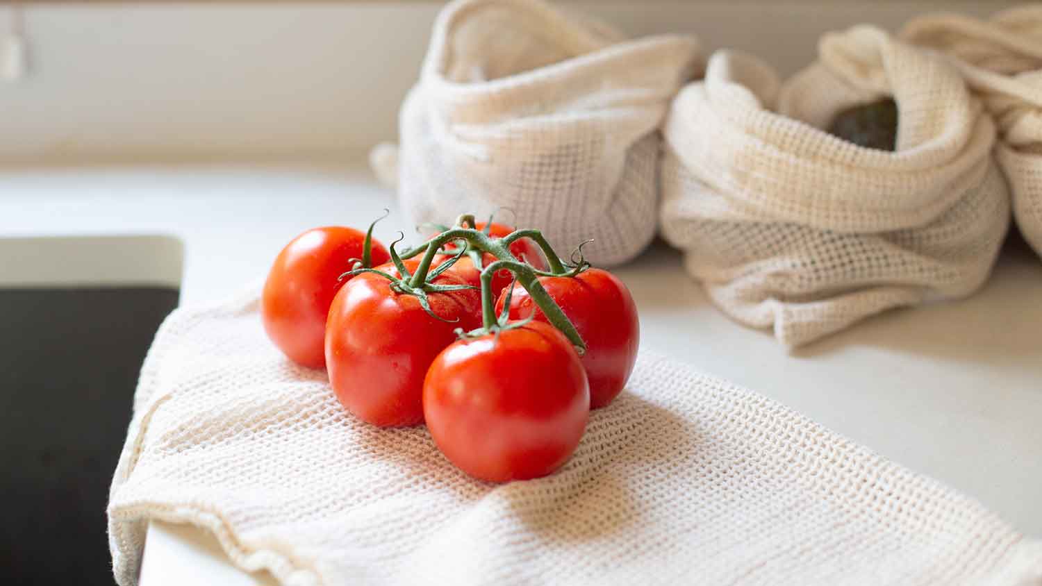 Tomatoes on the vine sitting on kitchen counter 