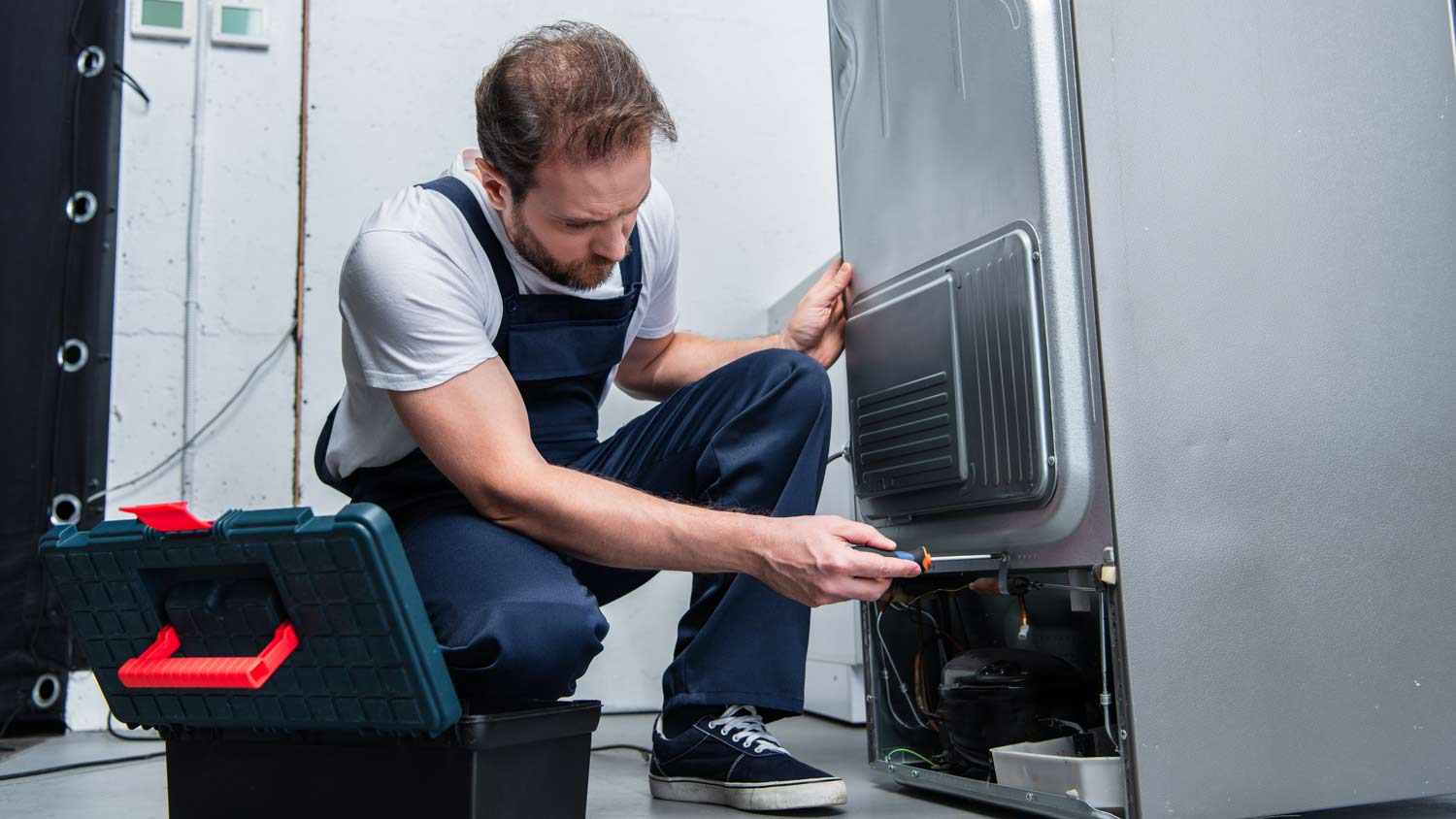 repairman working on fridge