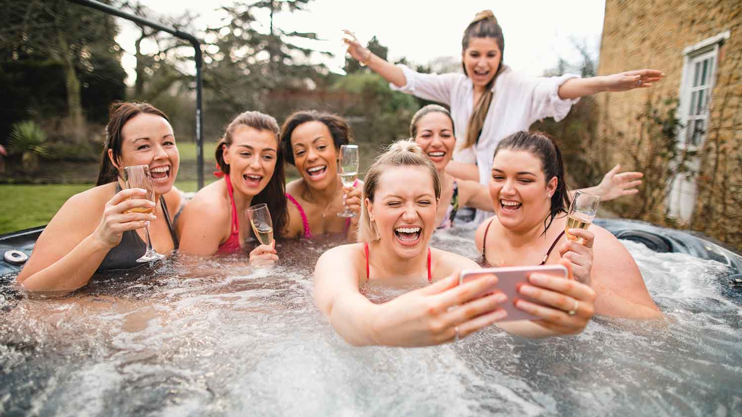 Group of friends having fun in a hot tub