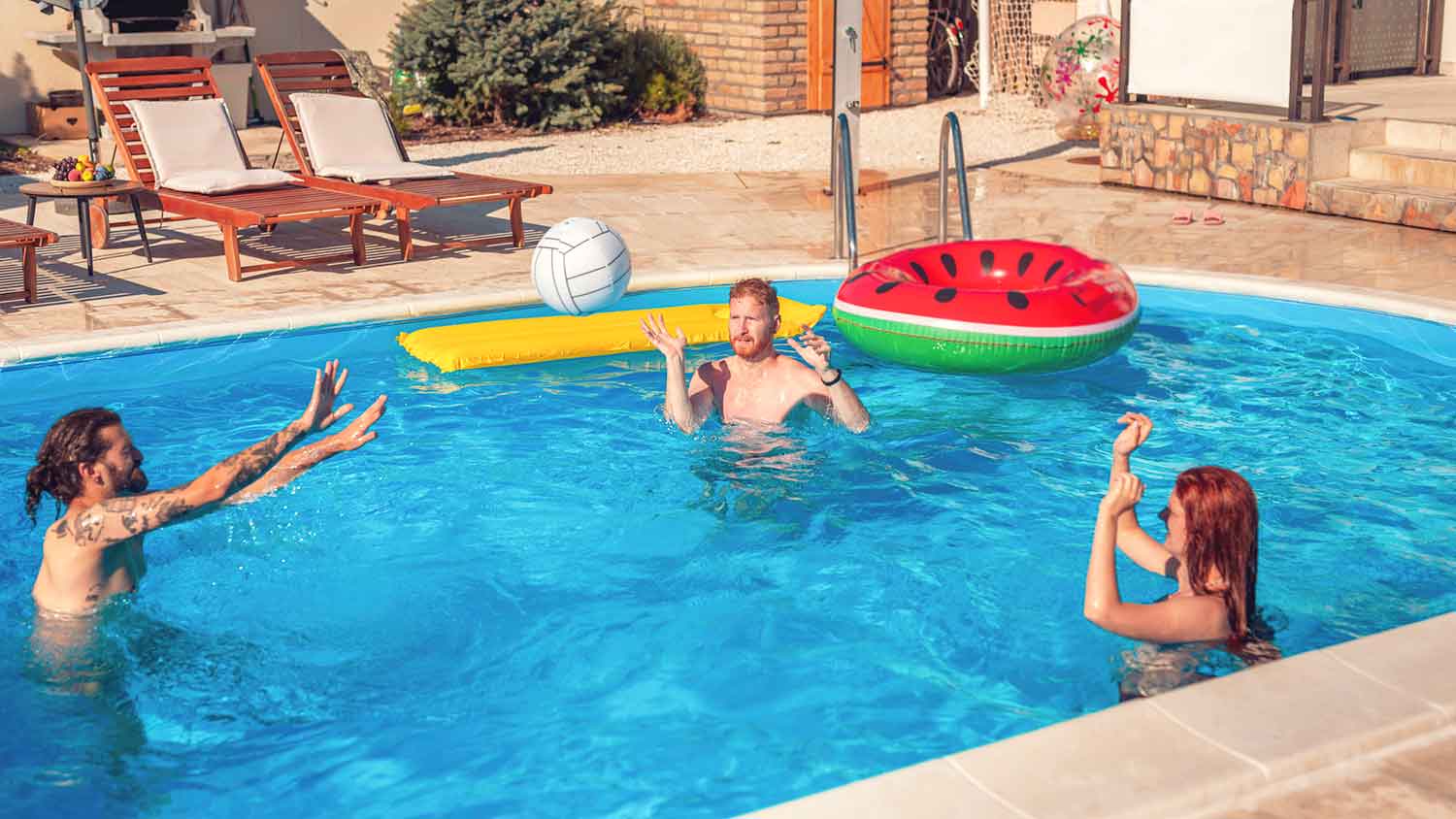 Group of friends playing volleyball in the pool