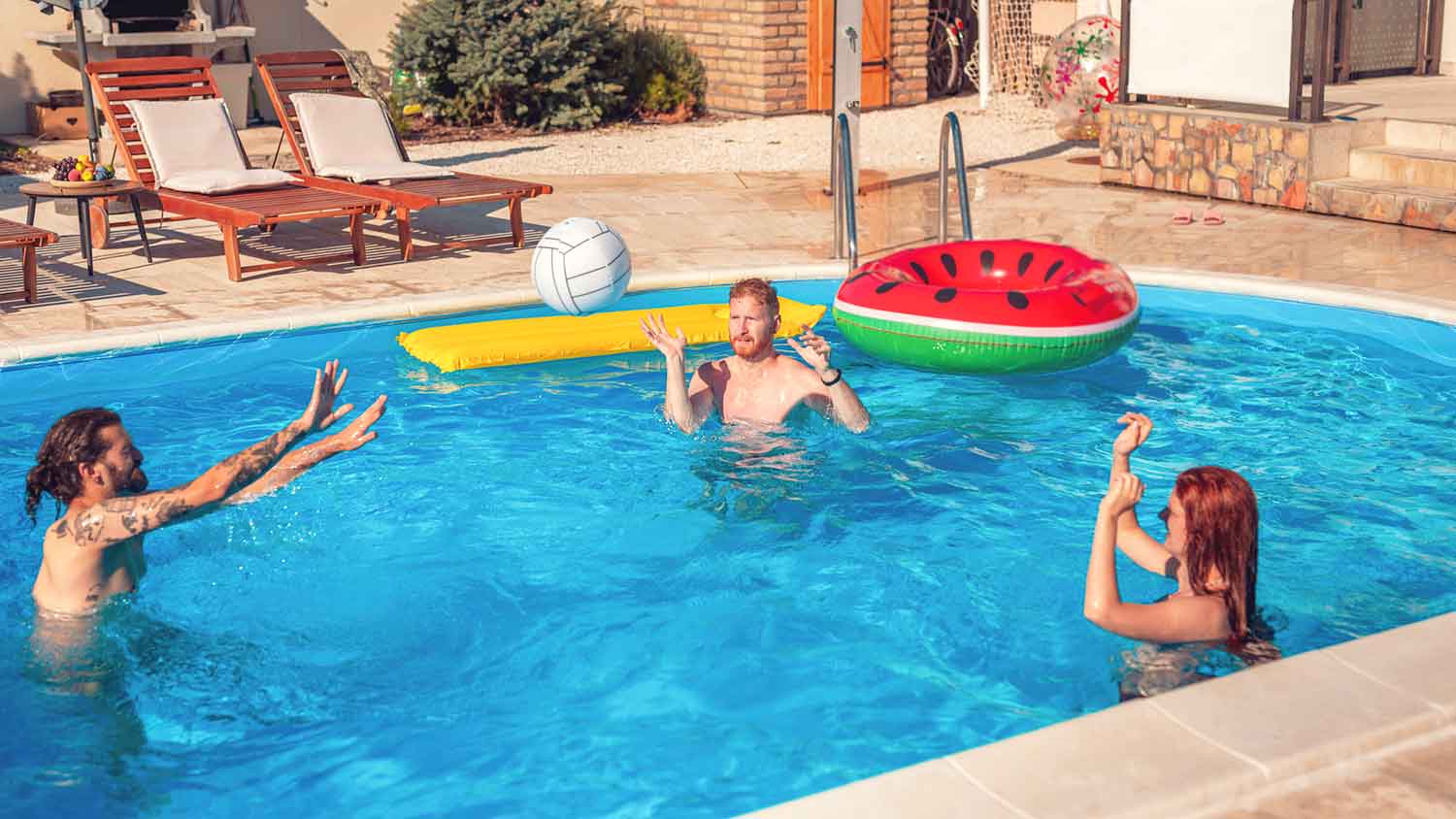 Group of friends playing volleyball in the pool 