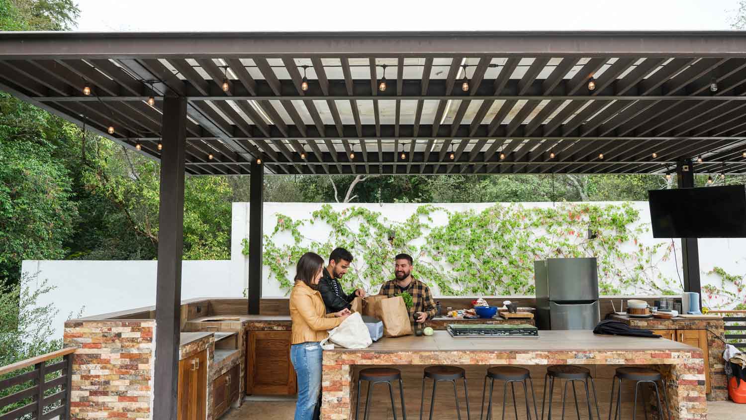 Friends preparing dinner in a covered outdoor kitchen