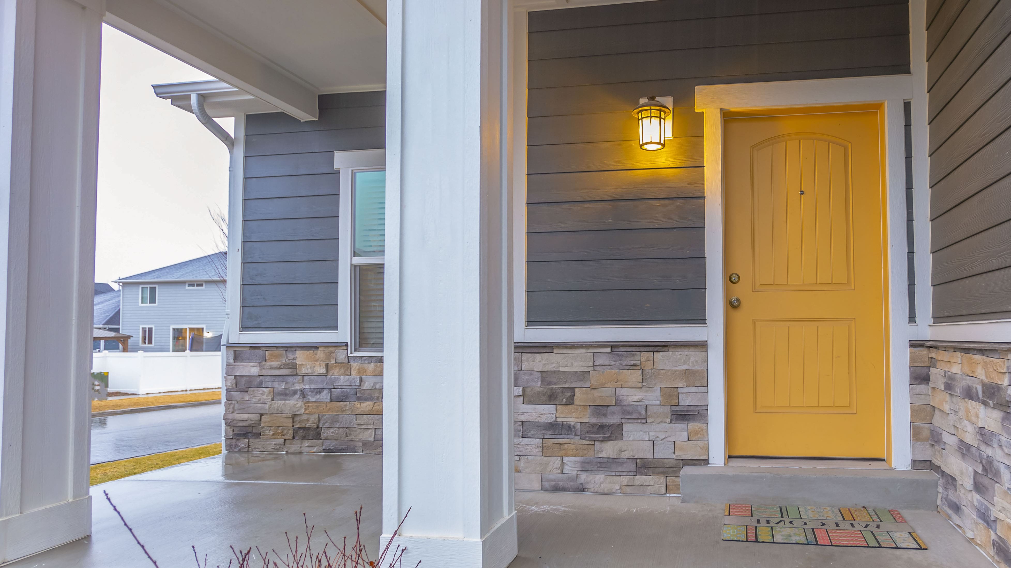 Front porch with bright yellow entryway door