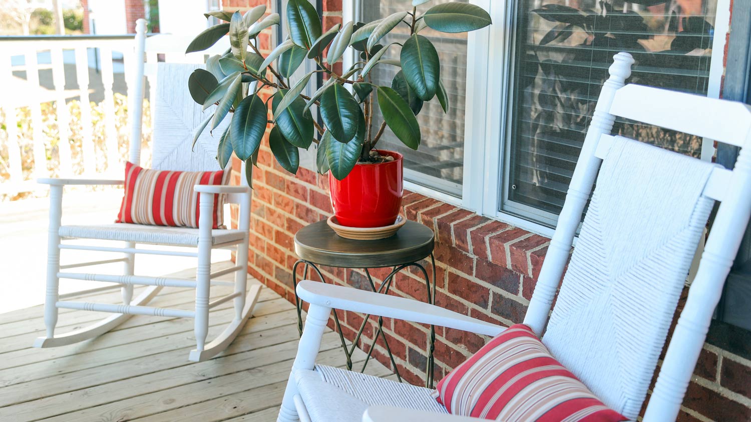 A closeup of a front porch with two rocking chairs