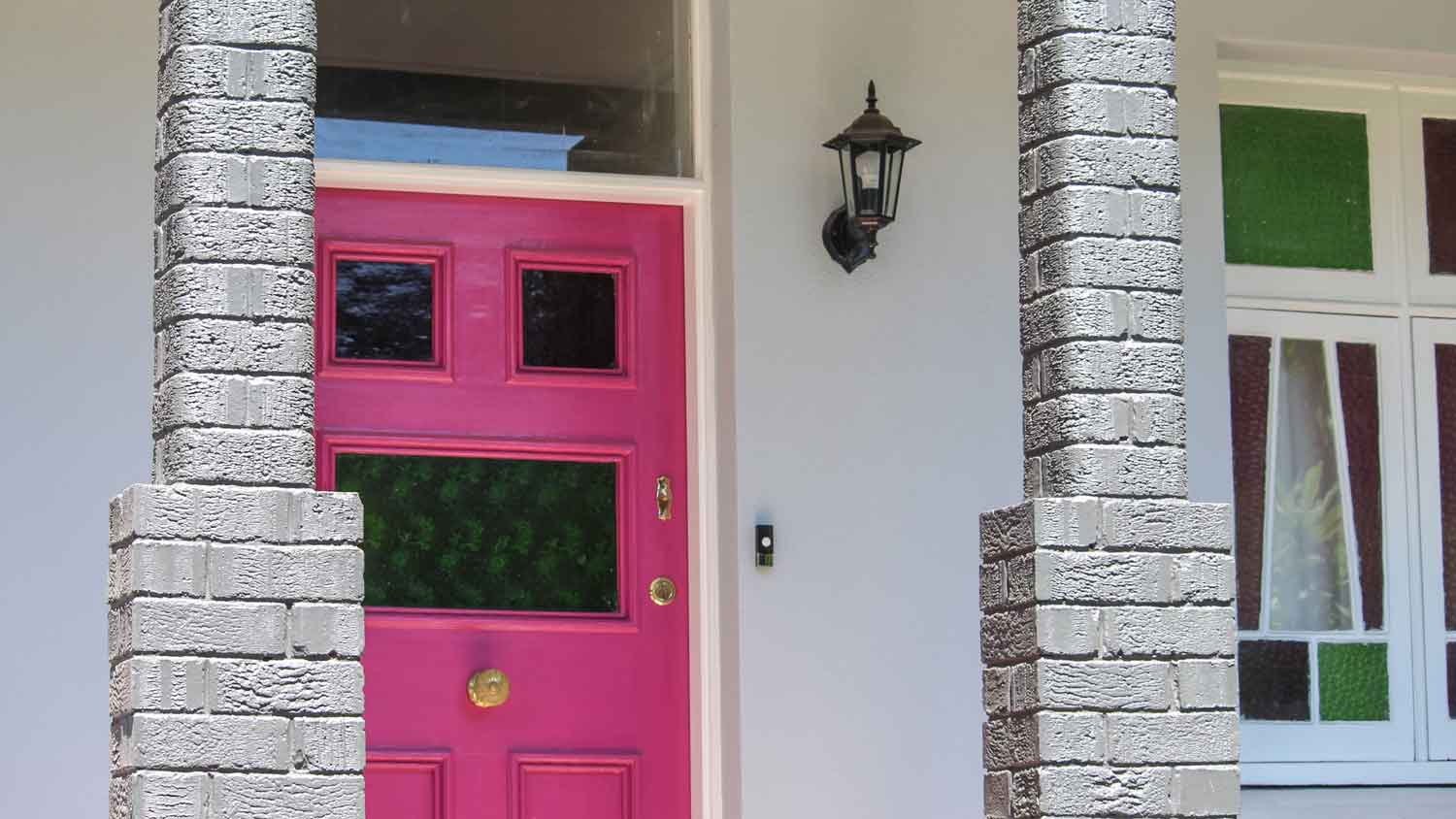 A front porch of a house with a pink veranda