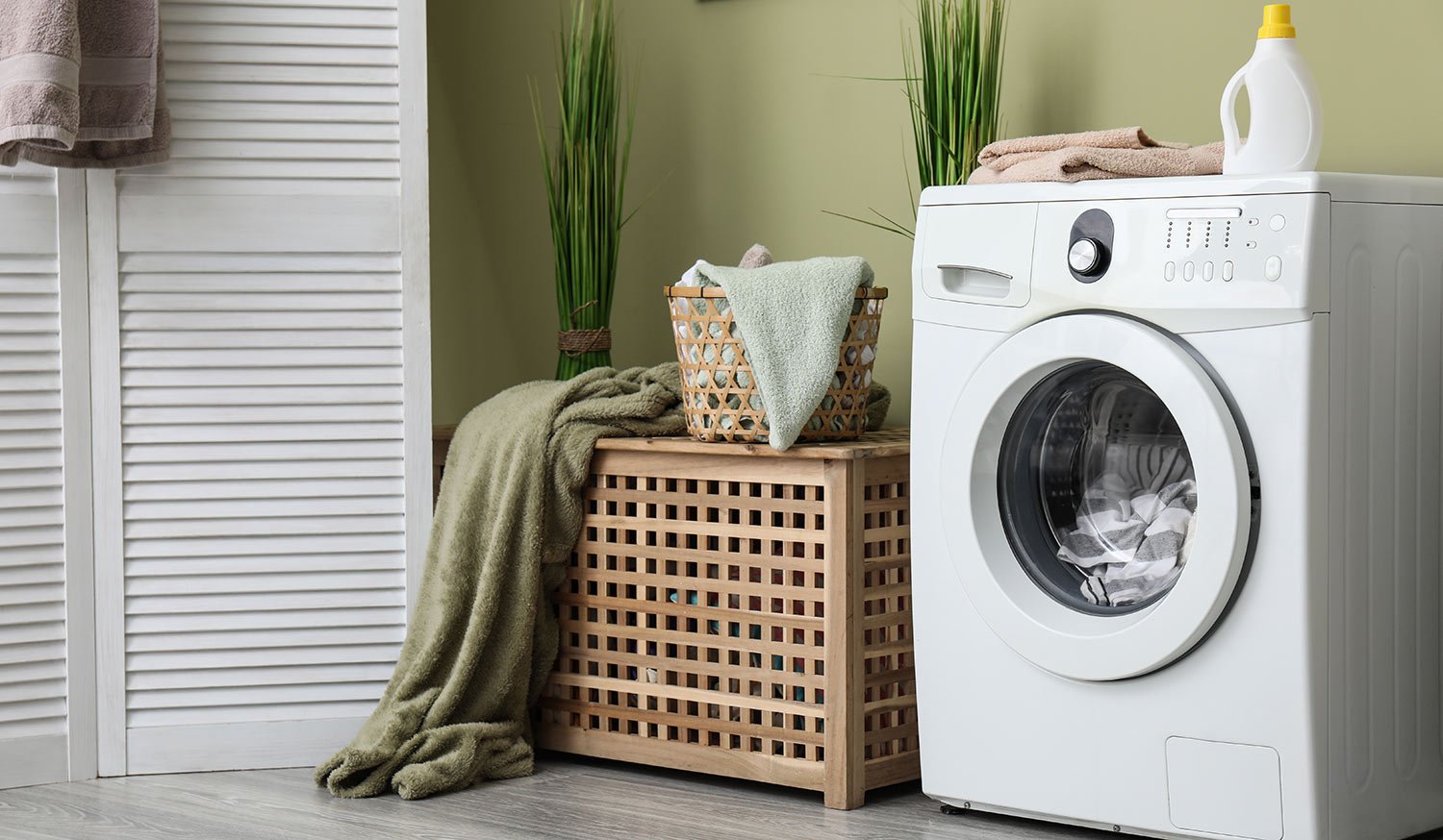 Home laundry room with full washing machine and basket