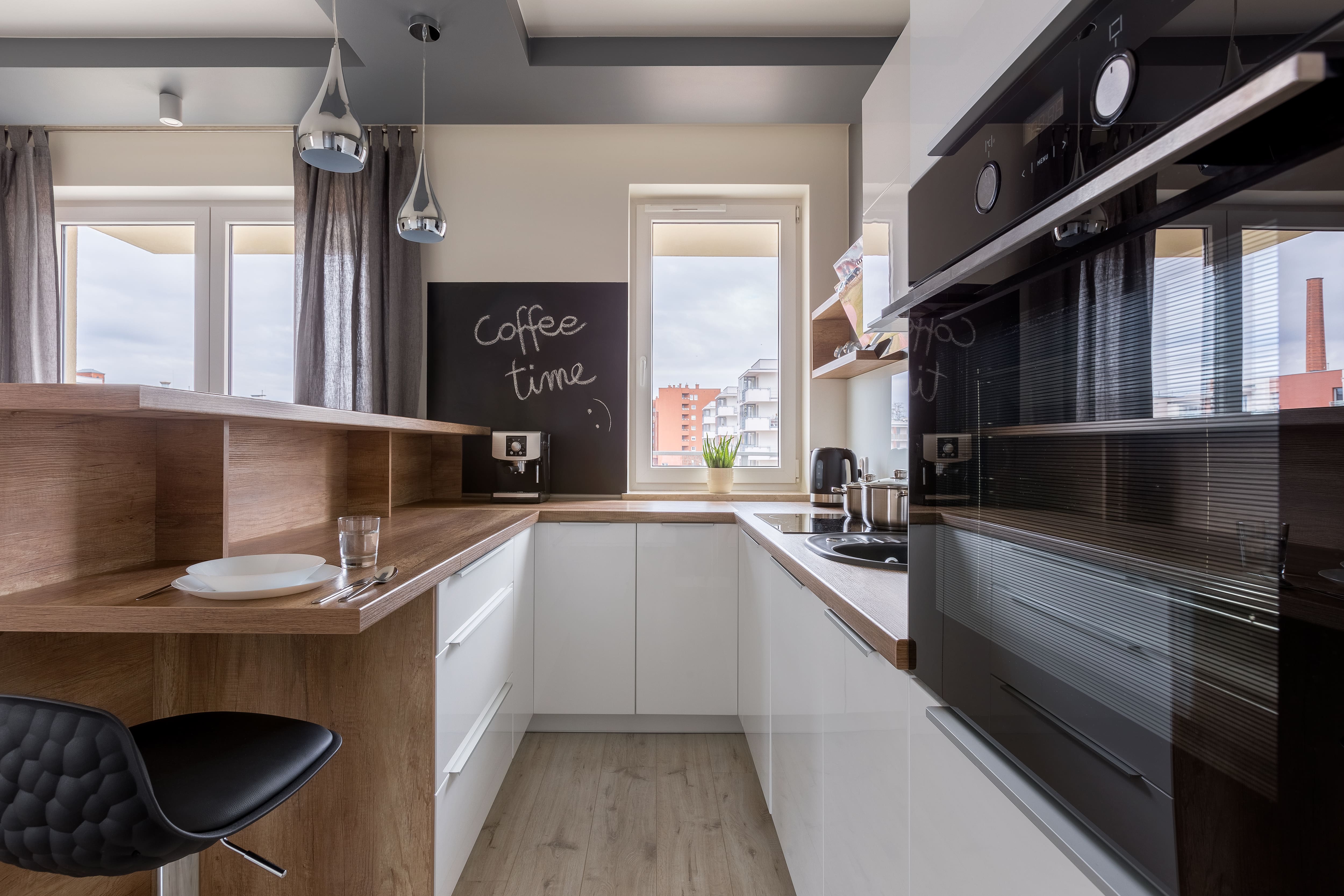 A contemporary kitchenette with a chalkboard wall