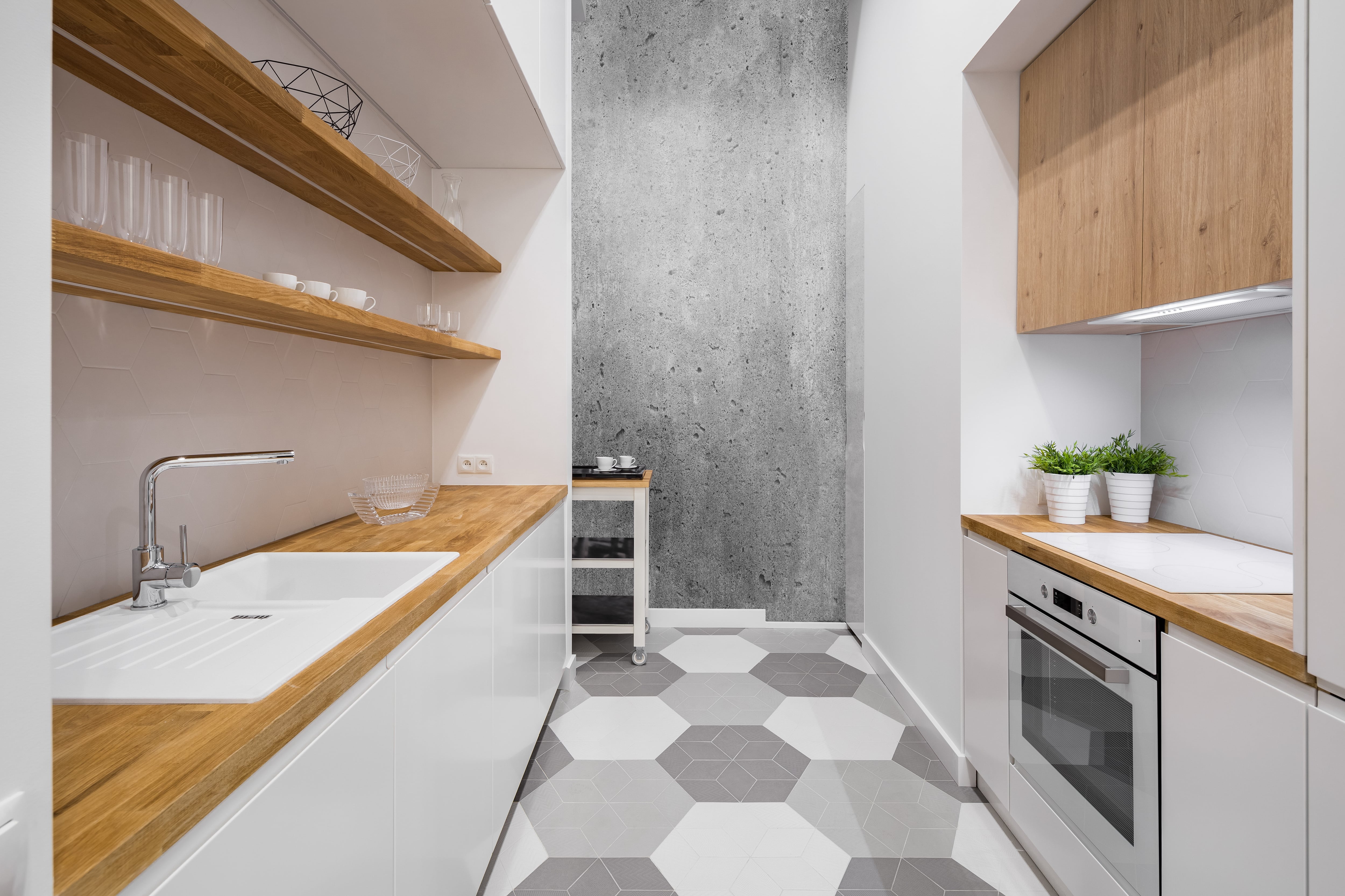 A white galley kitchen with wooden countertops and shelves Instead of cabinets