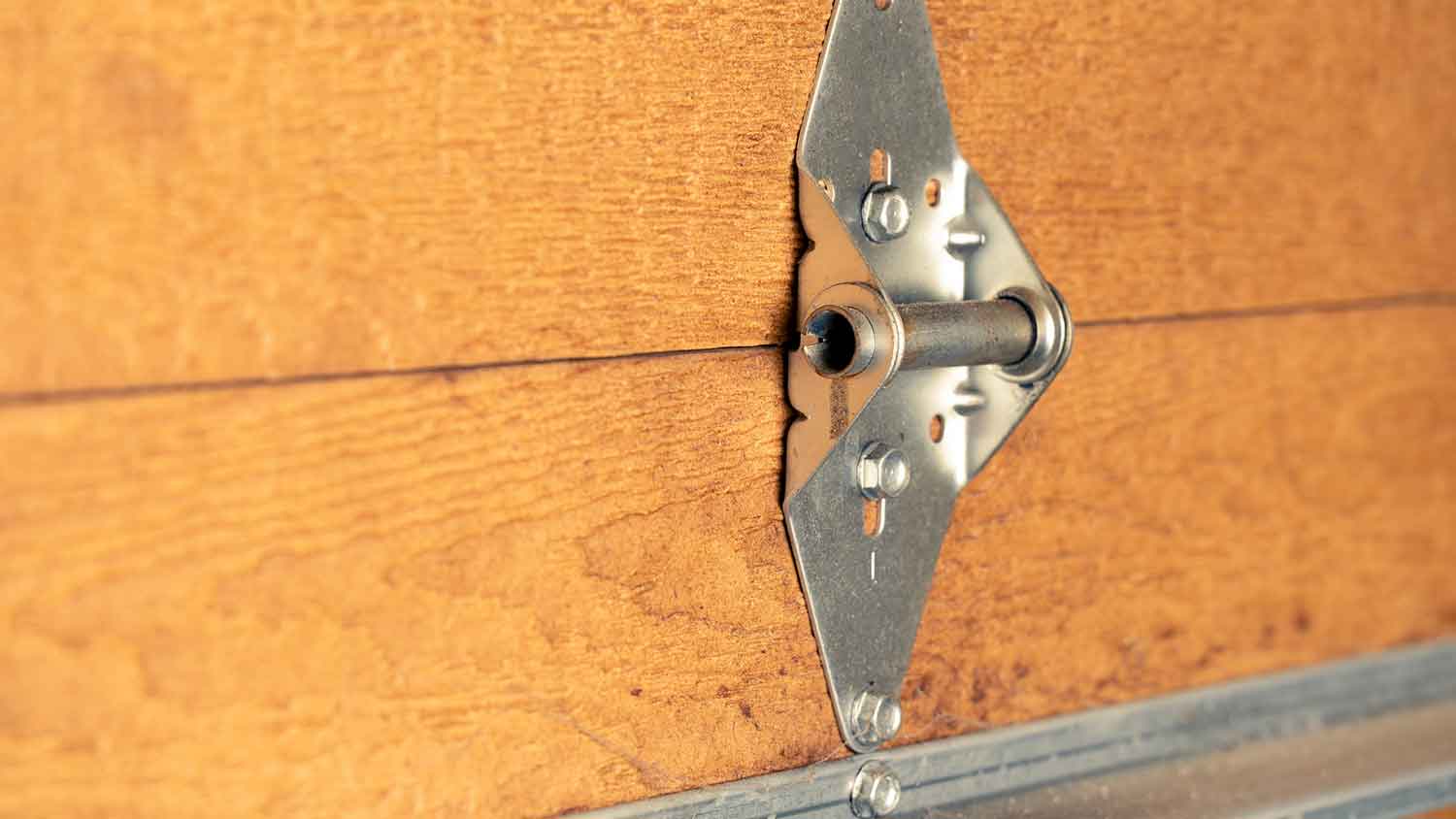 Garage door hinge on a wooden panel