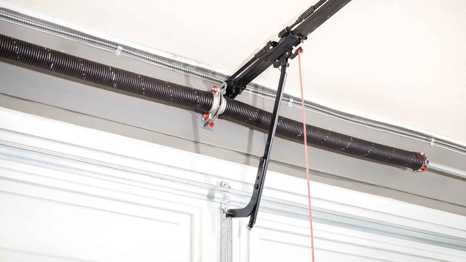 Torsion springs installed above automatic garage door 