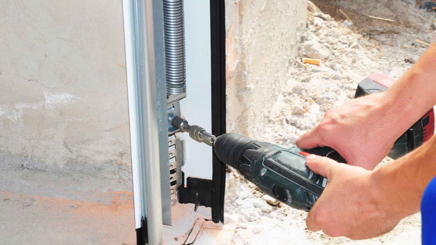 Worker installing garage door extension springs