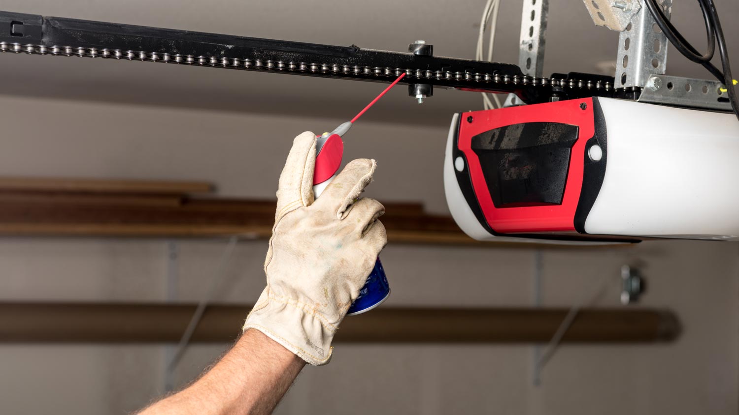 man applying oil to garage chain