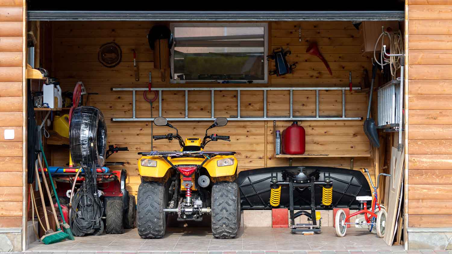 An open garage with an ATV and tools