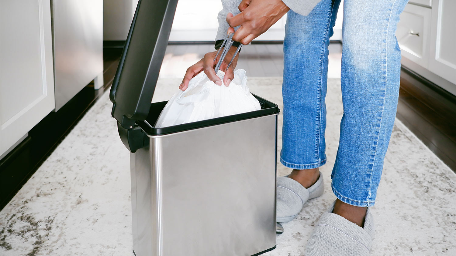 Kitchen person grabbing garbage bag