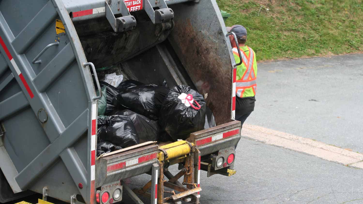 A garbage truck collecting garbage bags