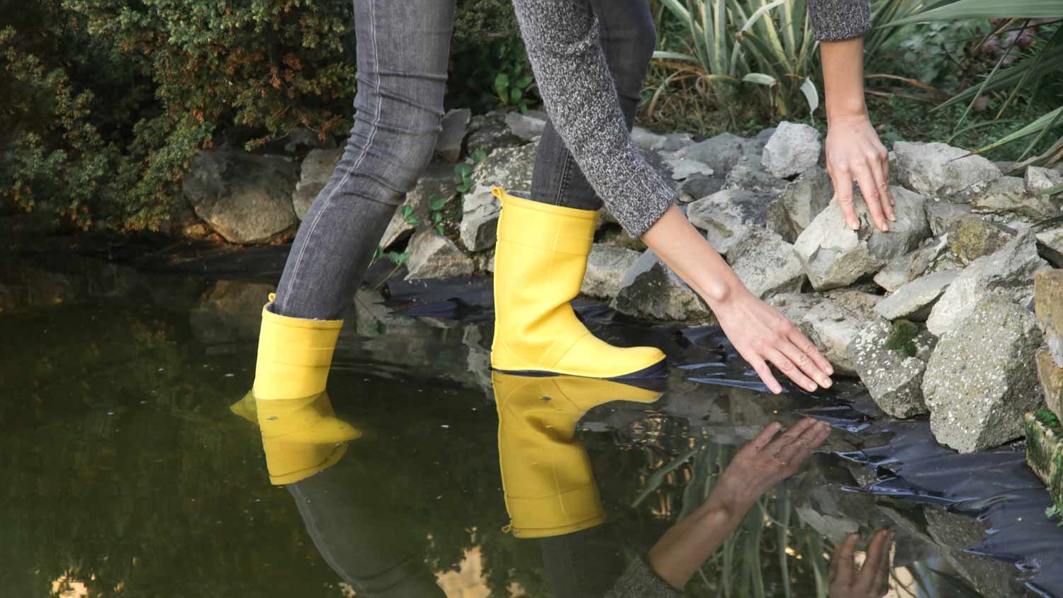 woman checking garden pond