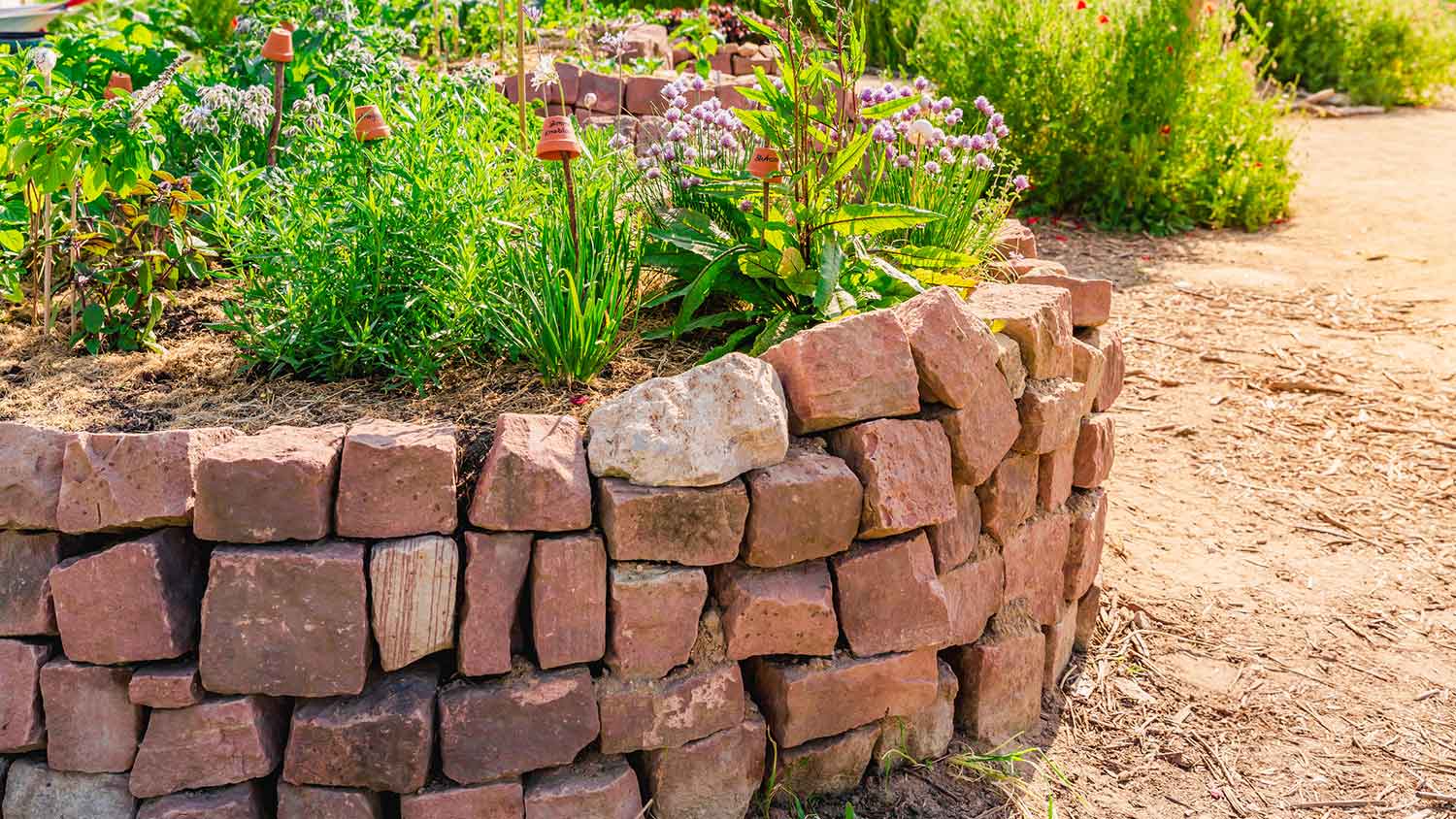 Garden retaining wall built with red rocks