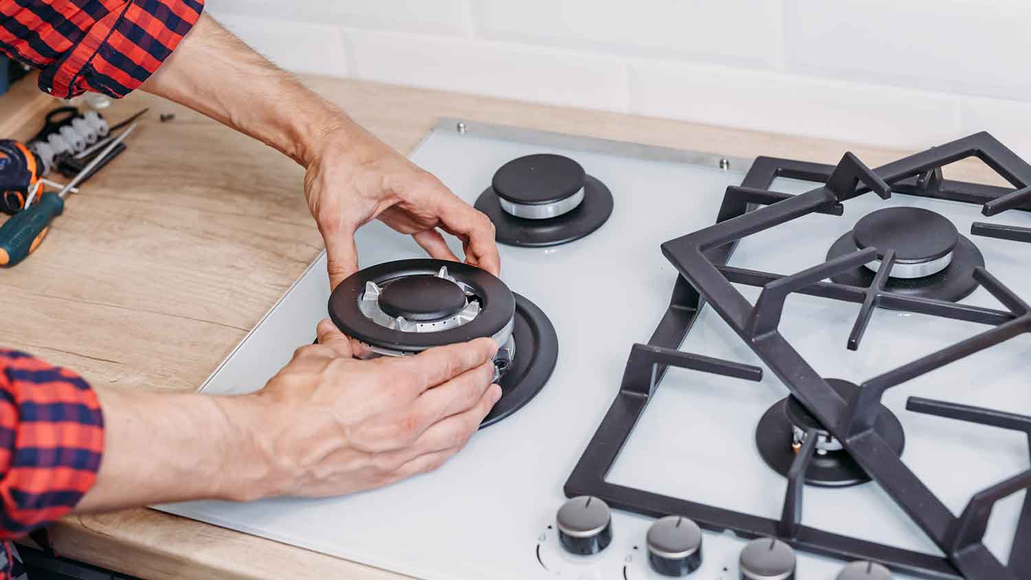 Technician repairing gas burner on a gas cooktop