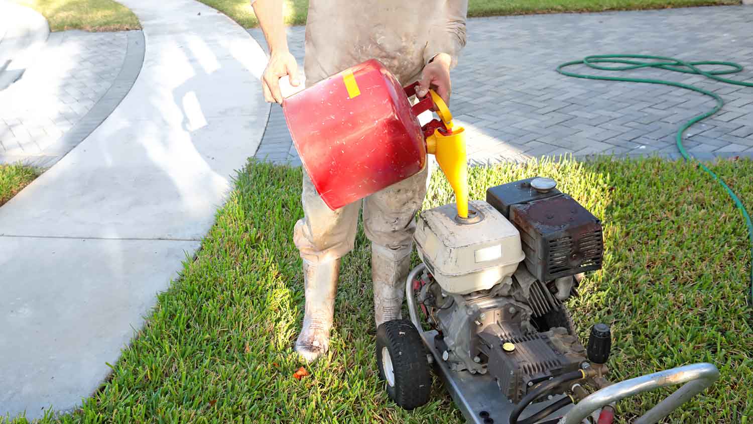 Man filling pressure washer with gas