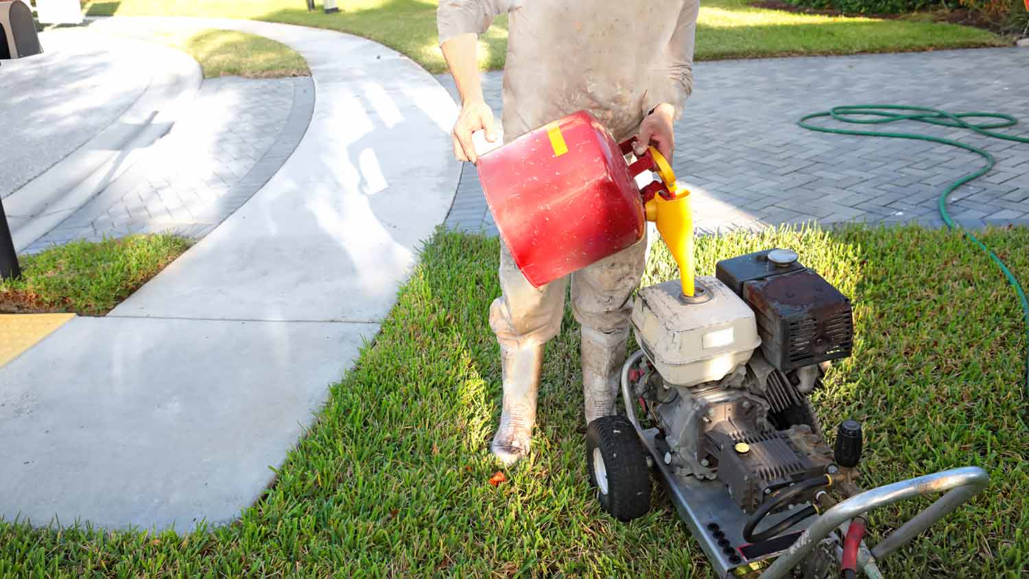 man filling pressure washer with gasoline