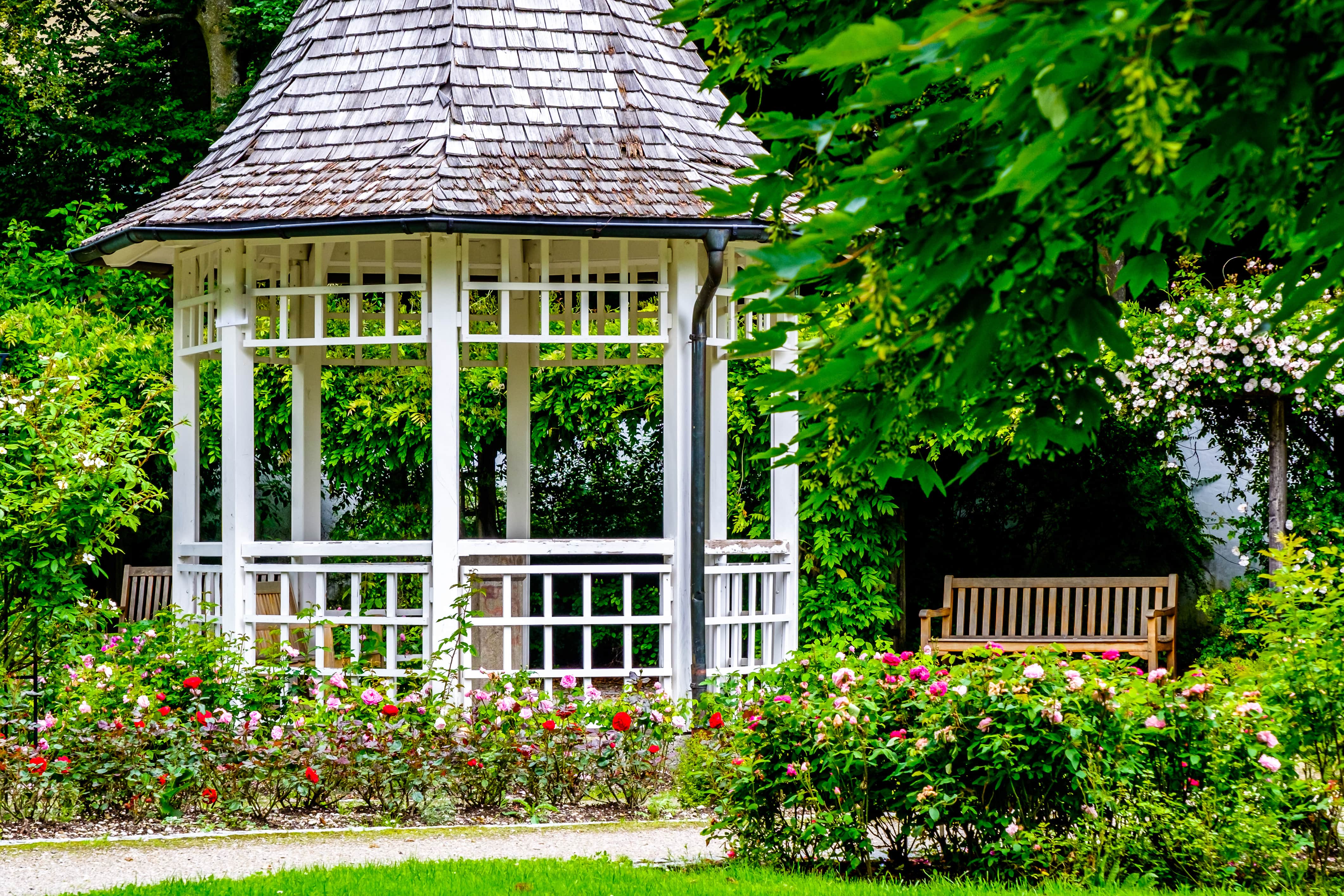 Gazebo in garden with flowers lining pathway