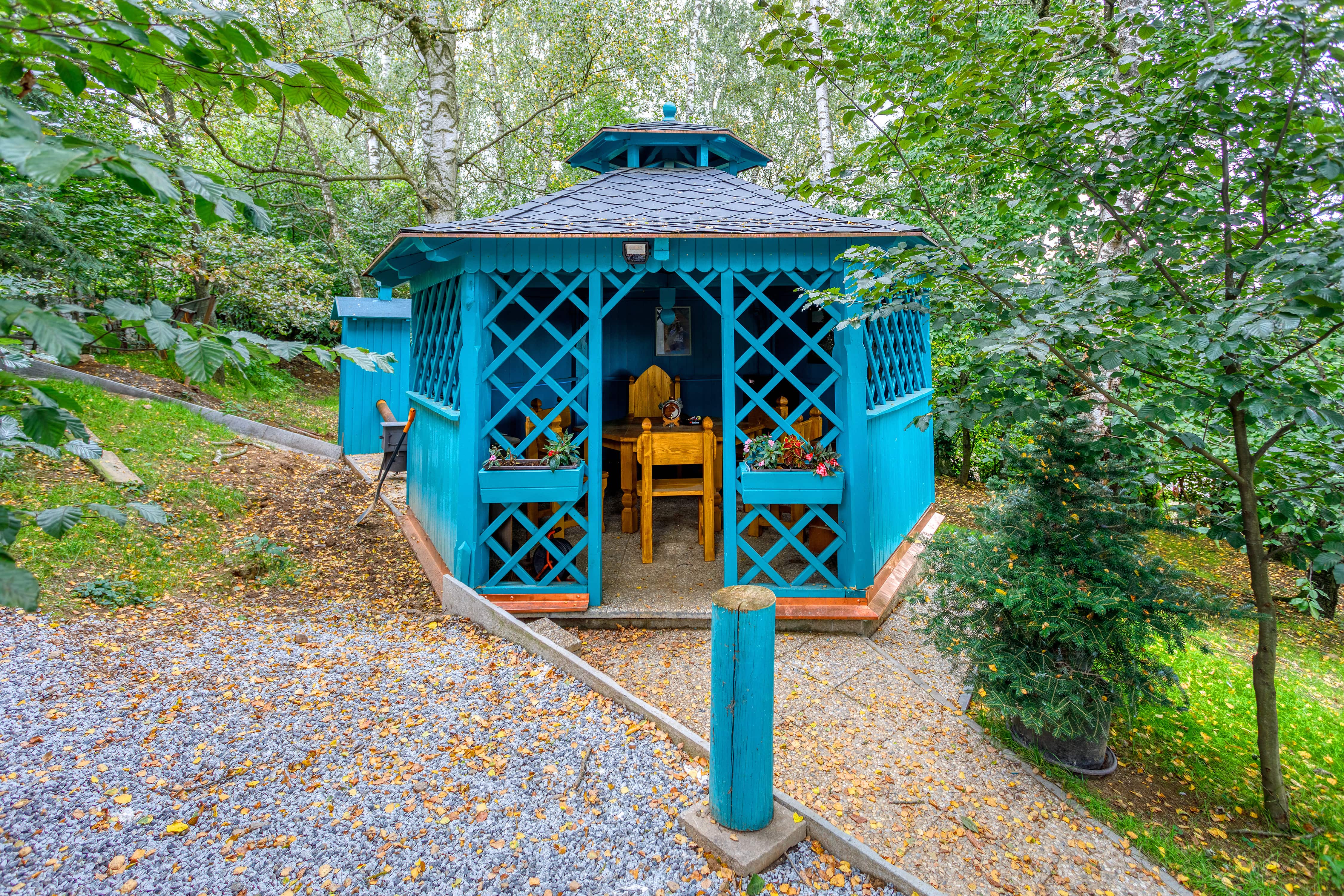 Wooden gazebo painted blue in backyard