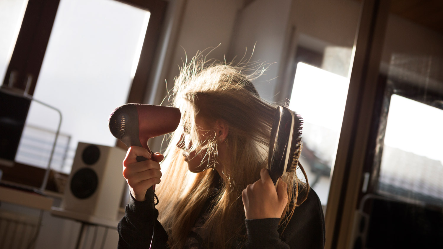 A girl blow drying her hair