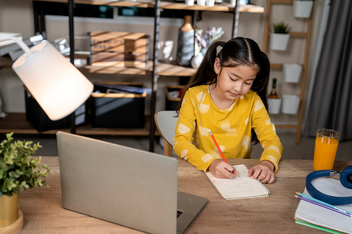 Girl siting at a desk doing her homework