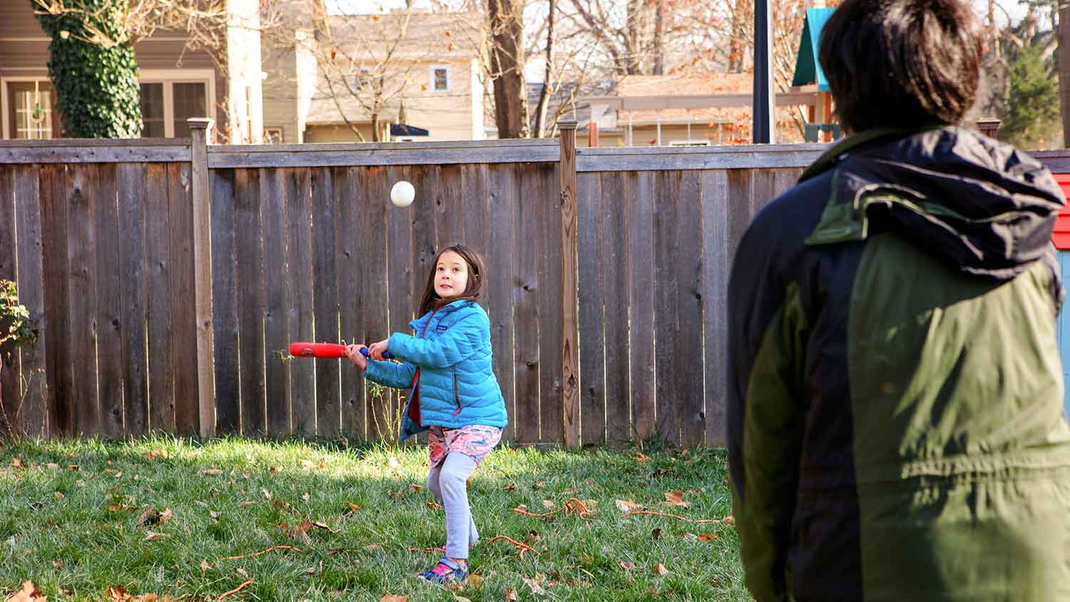 Girl playing softball in the yard