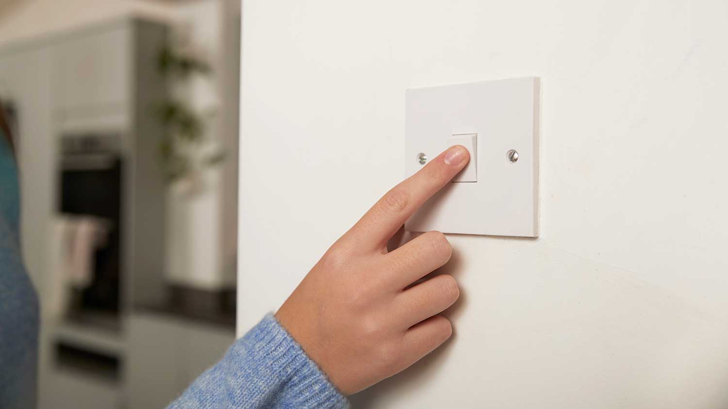 Girl tuning light switch on in the room